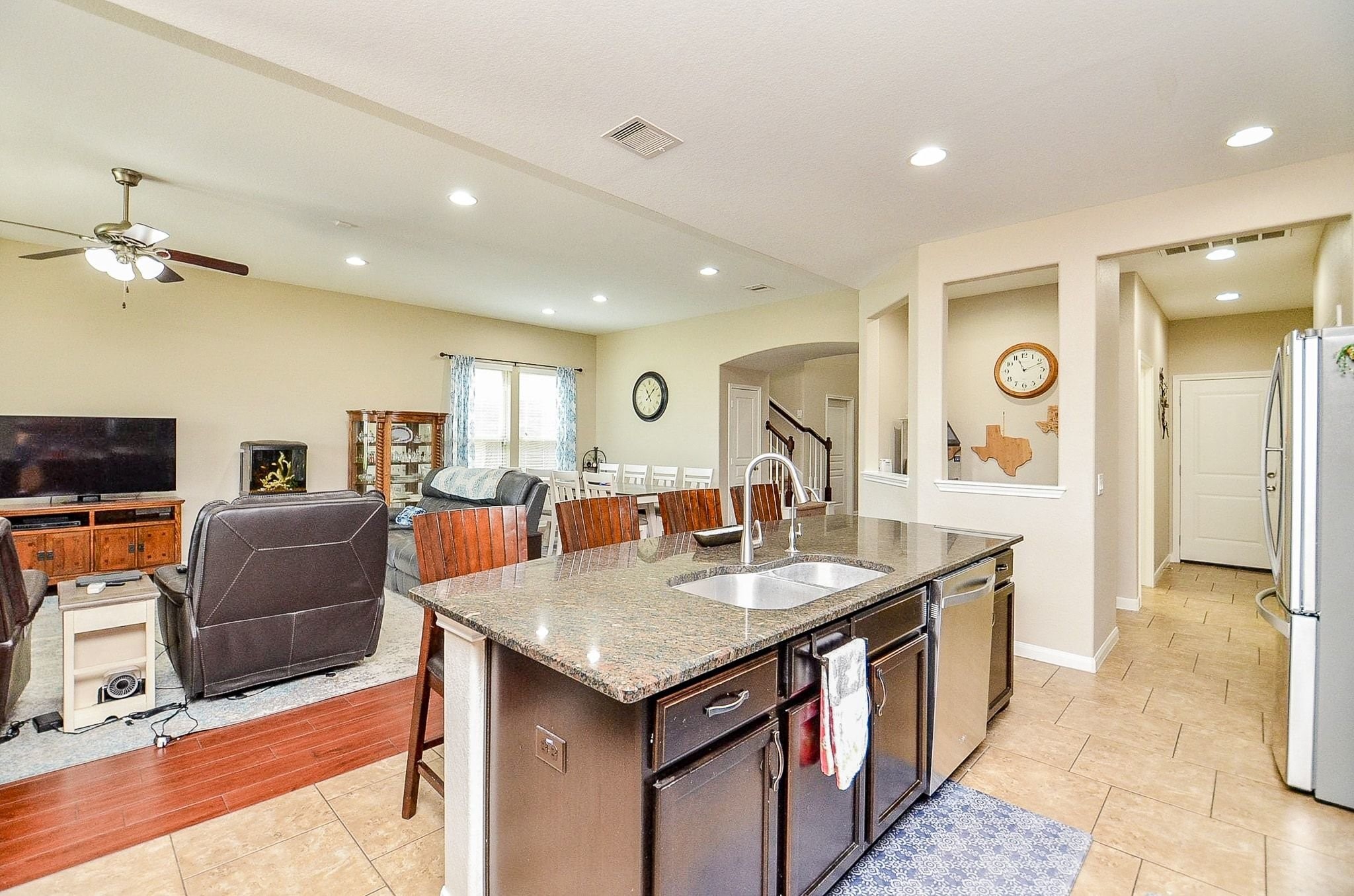 The large kitchen island with granite countertops opens up to the great room living room and dining room combination. There is an additional space next to the kitchen that could be used as a bar or smart home station.