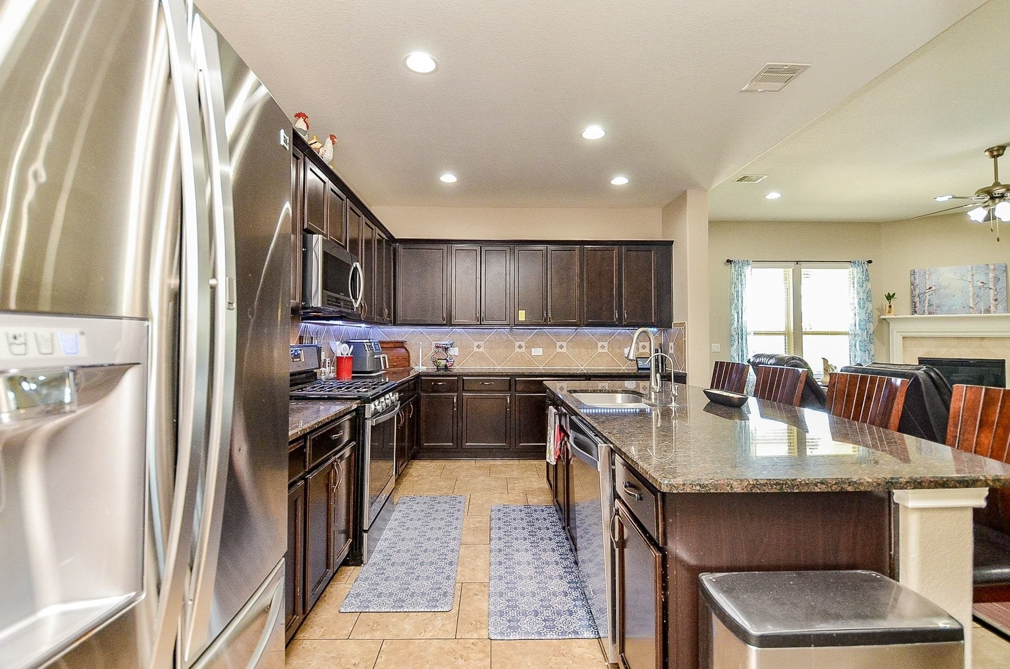 The kitchen features tons of cabinetry space and rich cabinetry.