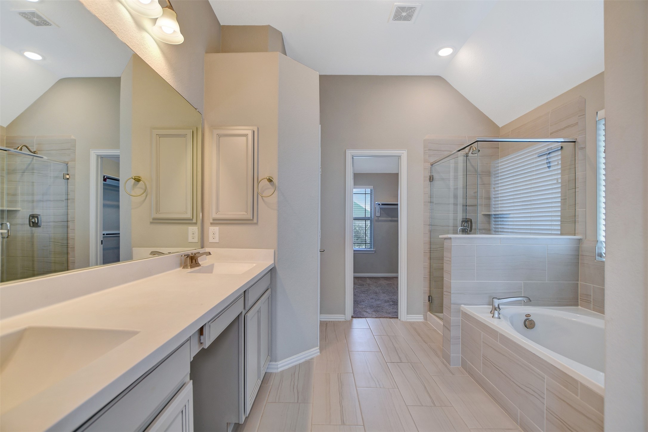 Large primary bathroom with dual sinks and separate shower and jettub.
