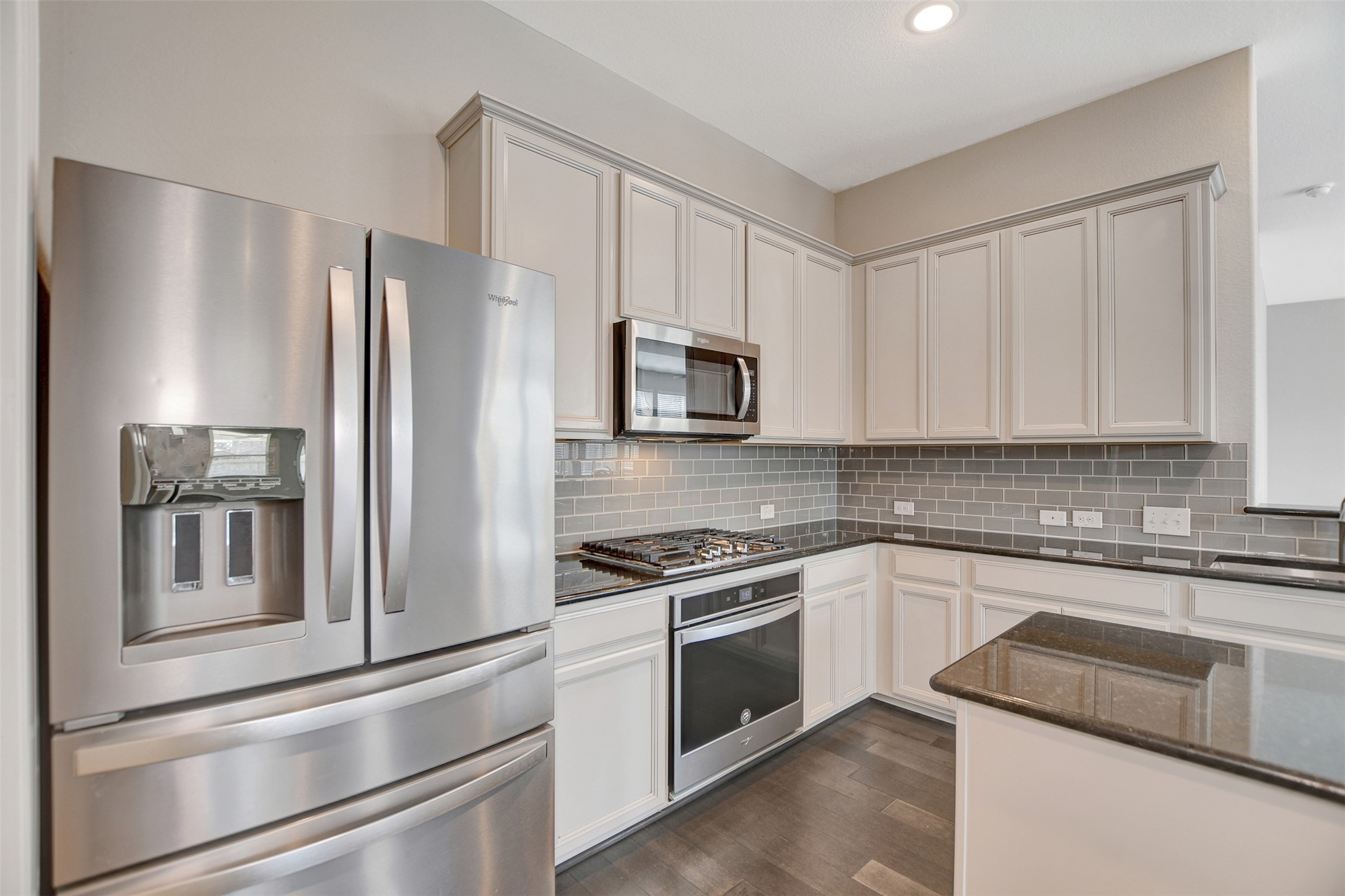 Light gray glass subway tile backlash with upgraded cabinets.