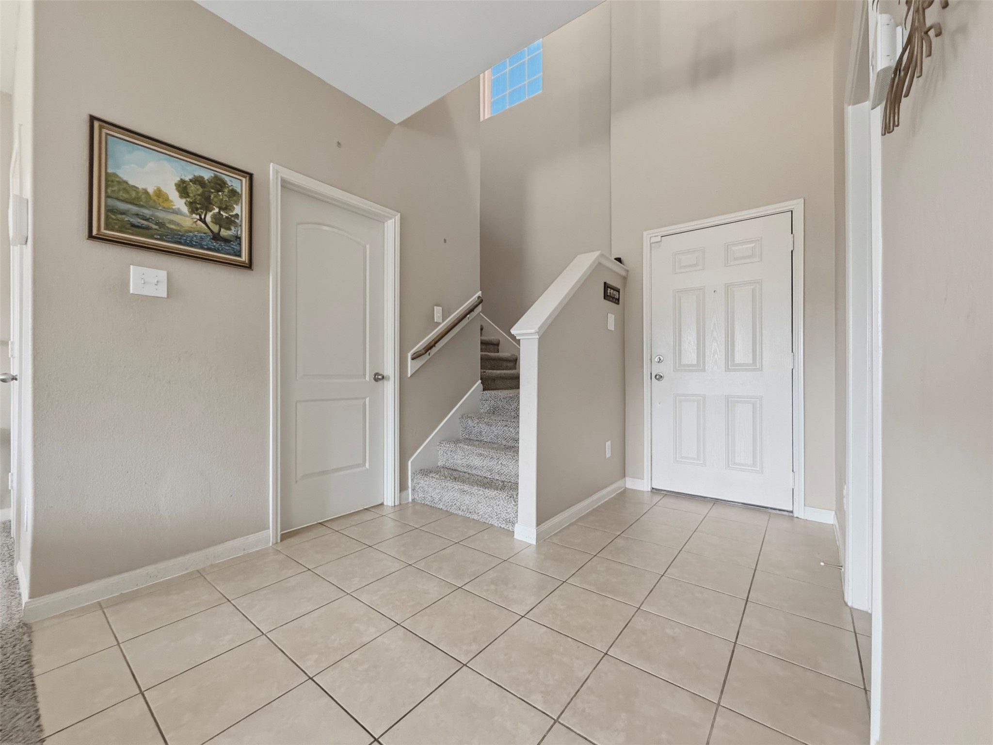 The half bathroom is located on the first floor to the left of the staircase and right next to the Living Room. The Primary Bedroom entrance (not visible in the photo) is located directly across from the door to the half bathroom.
