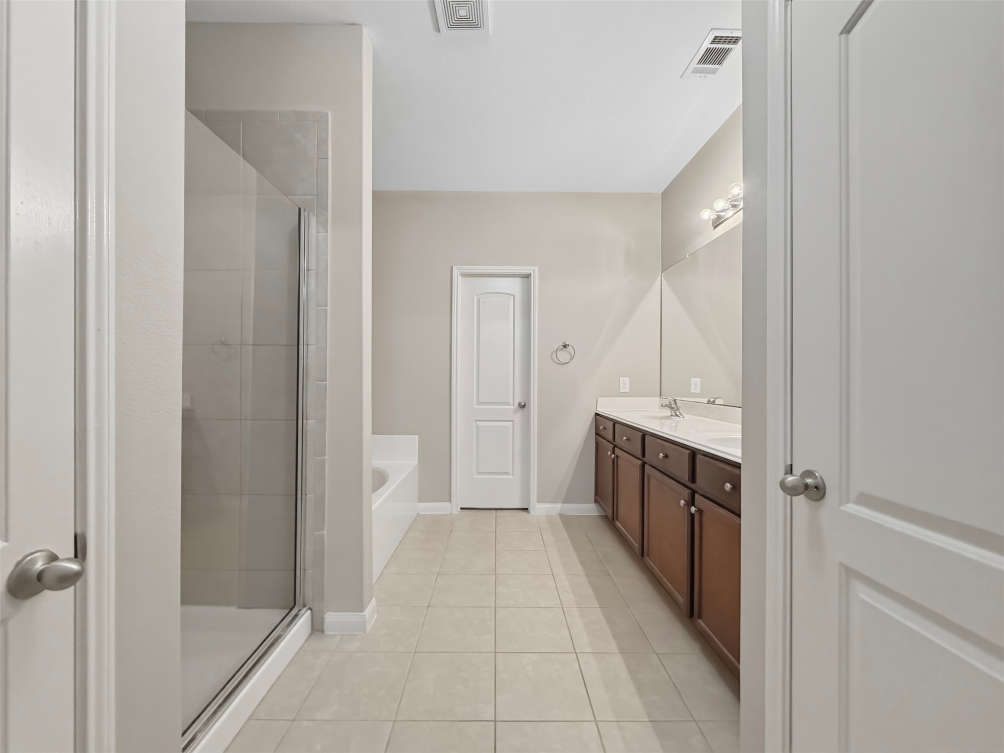 Walking into the Primary Bathroom, youll see the door to the private water closet and sinks/vanity on the right. The first door to the left is a linen closet.
