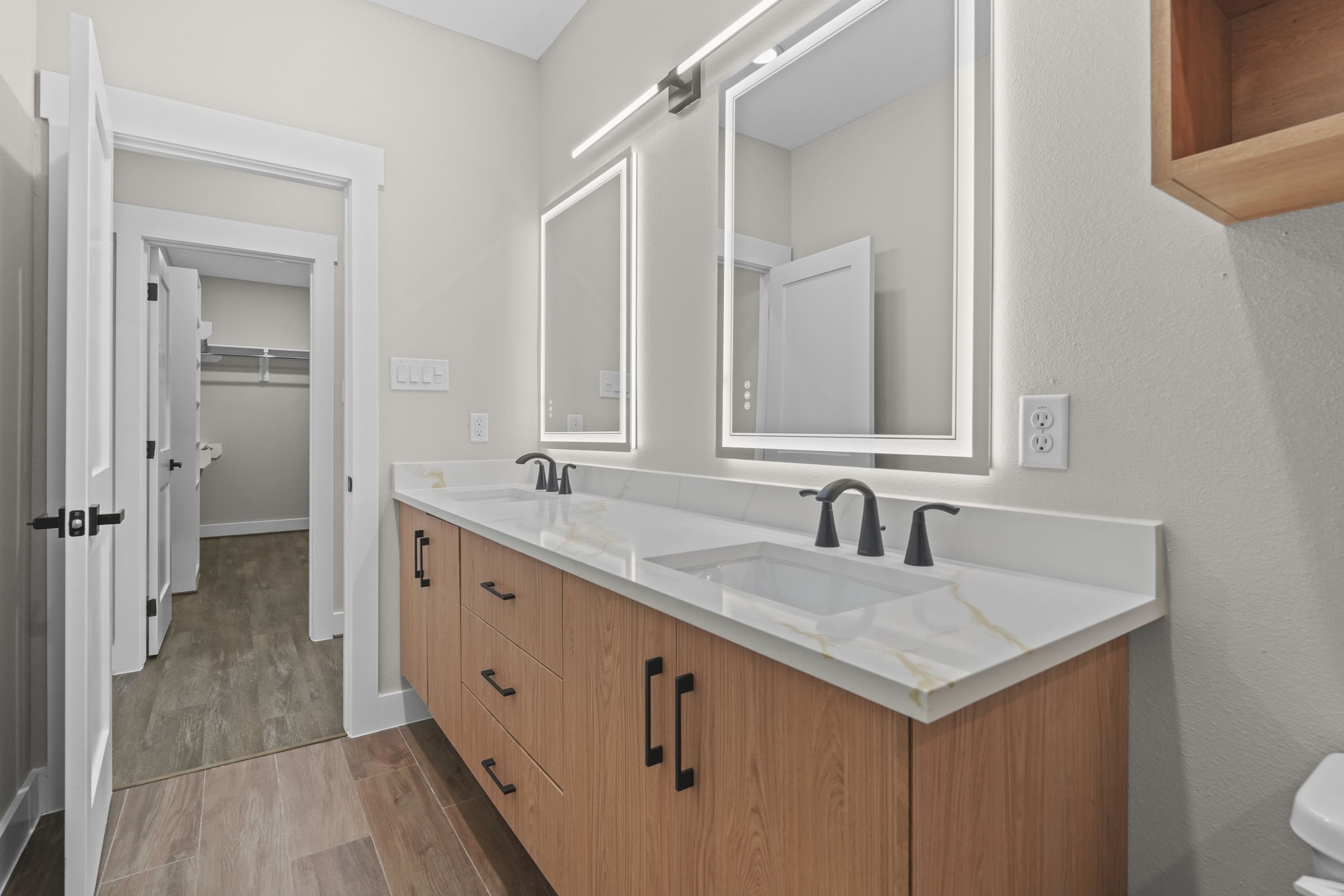 The functional floor plan offers excellent room clearance, seamlessly connecting the vanity zone directly to an adjoining walk-in closet.