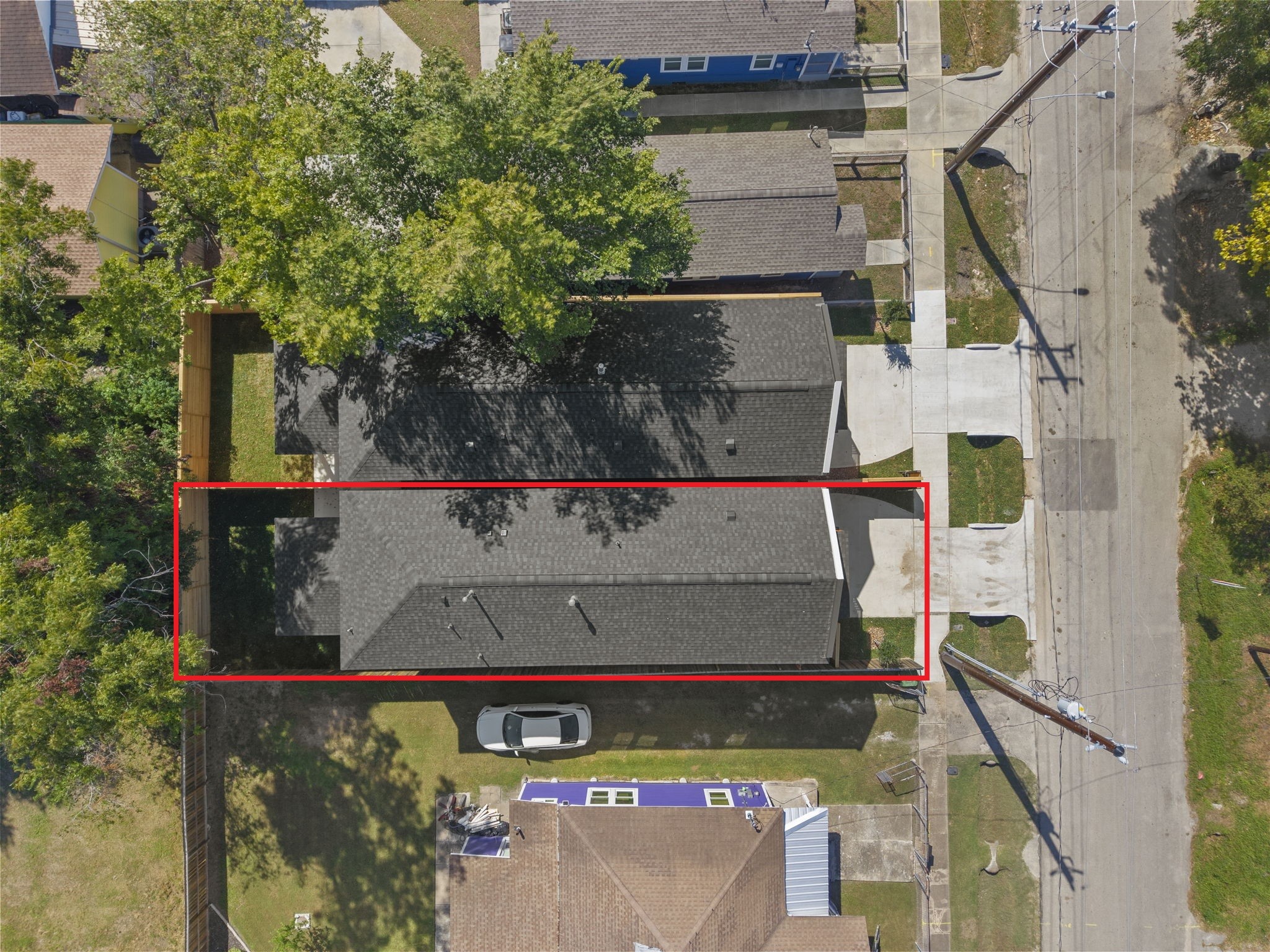 This top-down aerial shot highlights the rectangular property footprint and well-defined site boundaries. The footprint highlights a dedicated front driveway, a streamlined main structure, and a private enclosed backyard set.