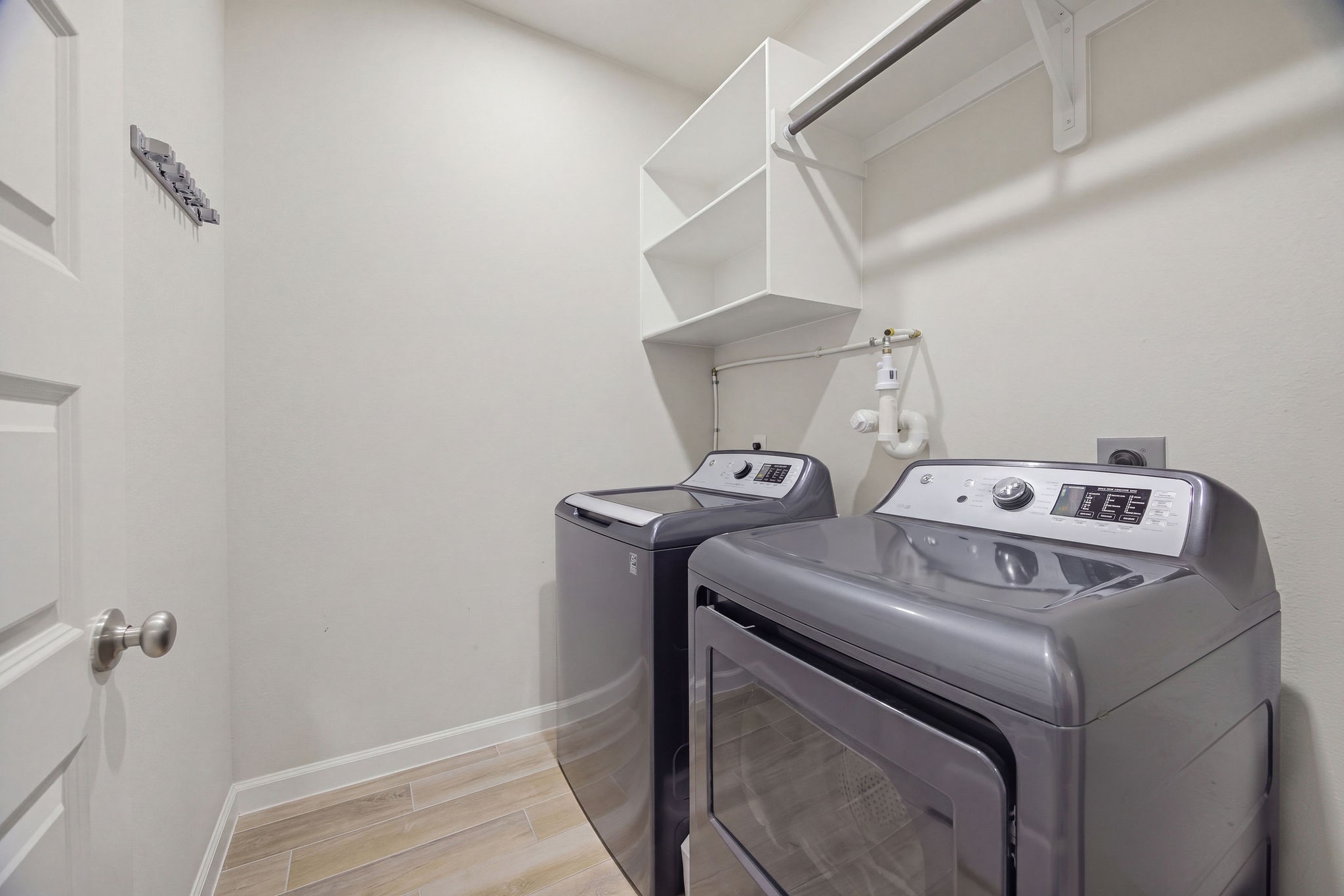Large walk-in laundry with shelves and hanging space