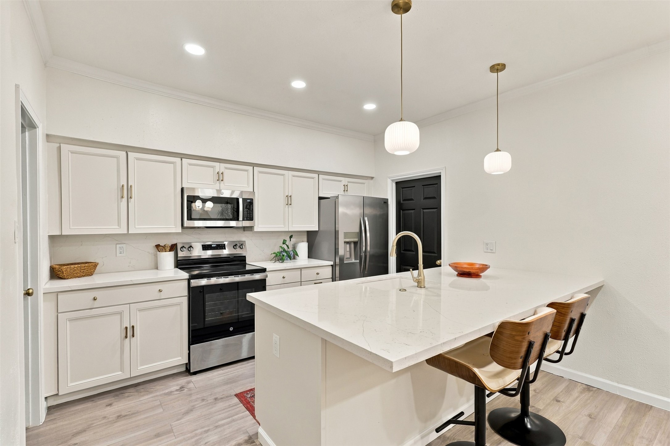 The renovated kitchen centers on an expanded quartz island with seating for three to four.