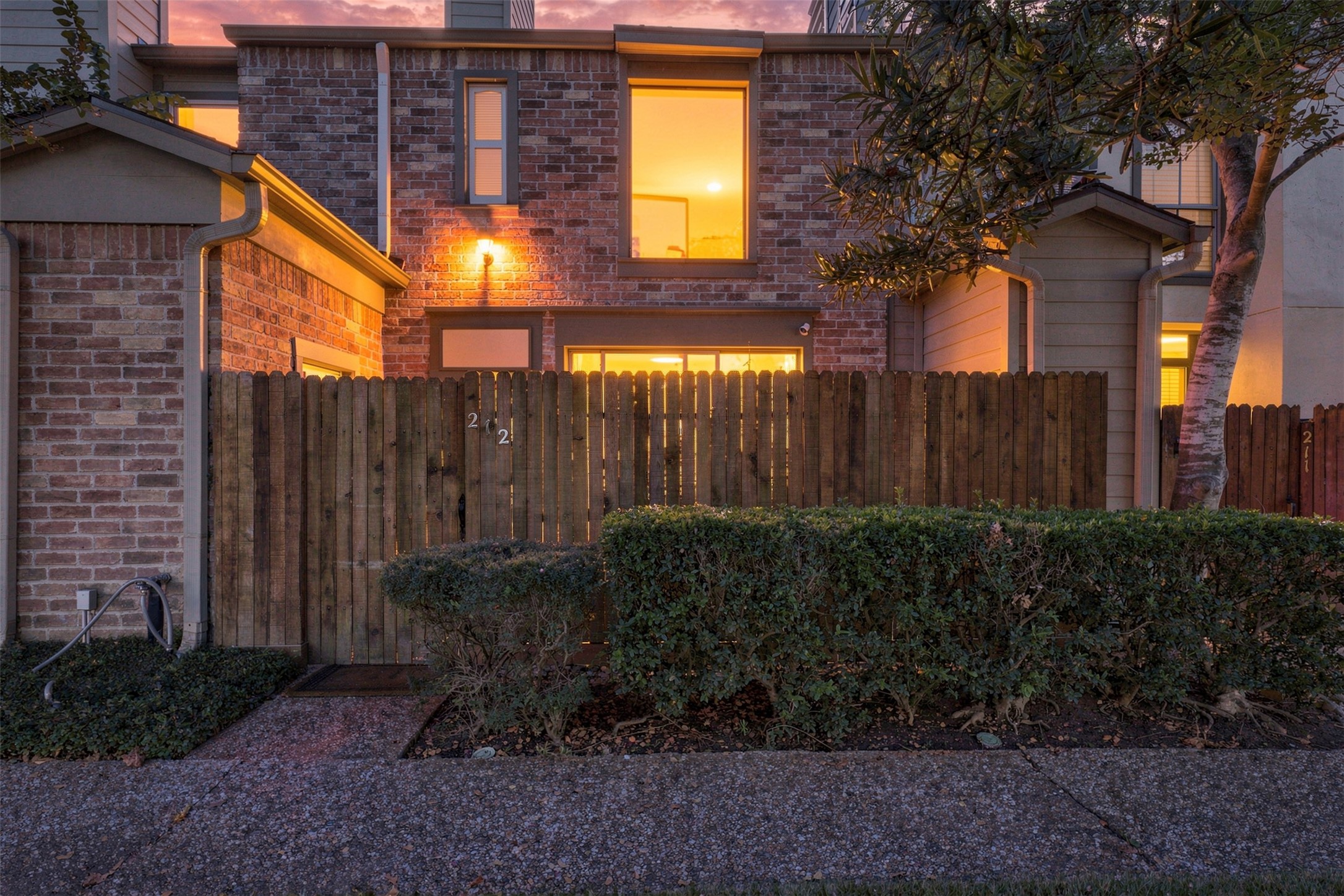 At dusk, the brick exterior and enclosed courtyard introduce a peaceful retreat within River Oaks Place.