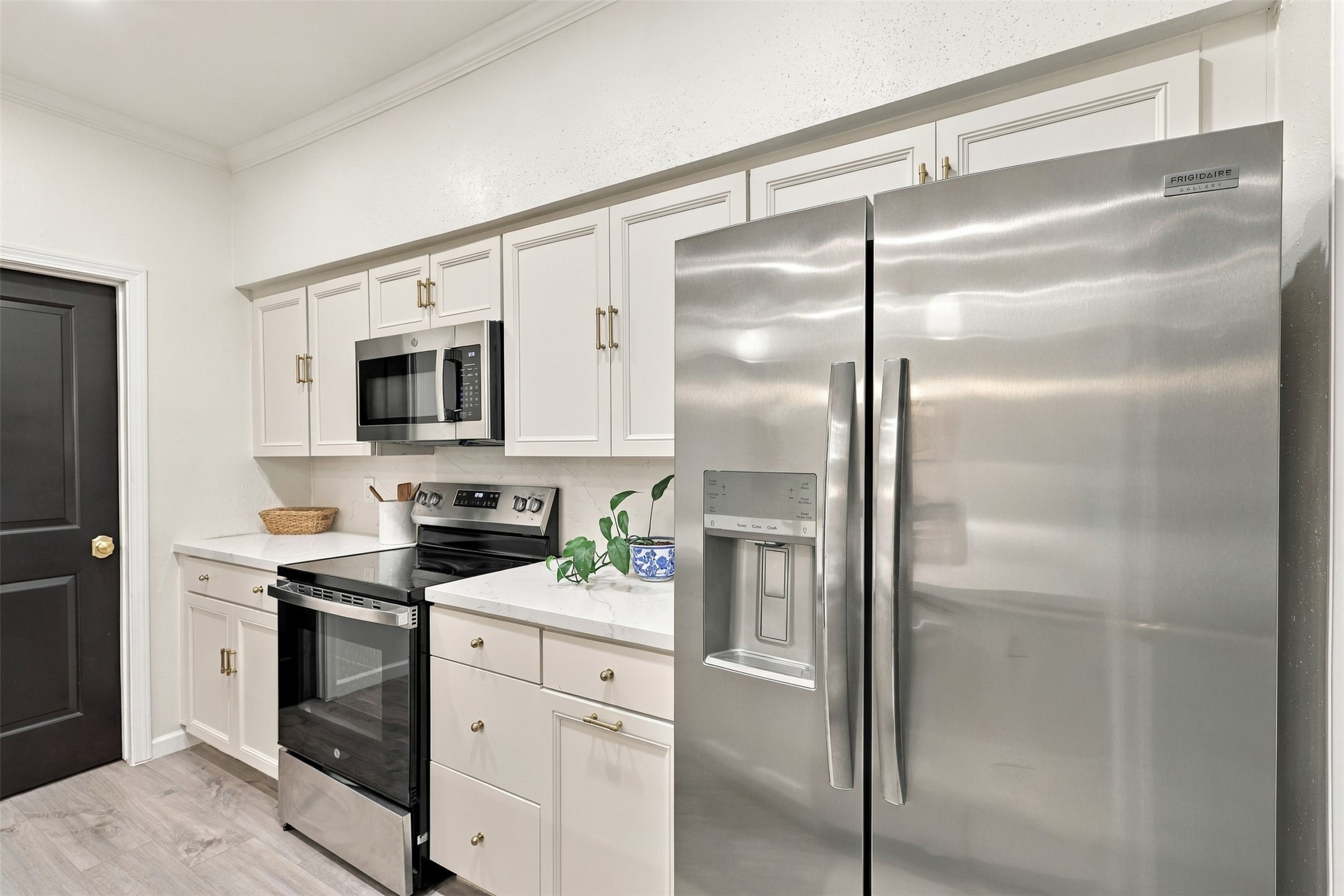 Modern kitchen with sleek stainless steel appliances, crisp white cabinetry, and elegant countertops for a stylish cooking space.