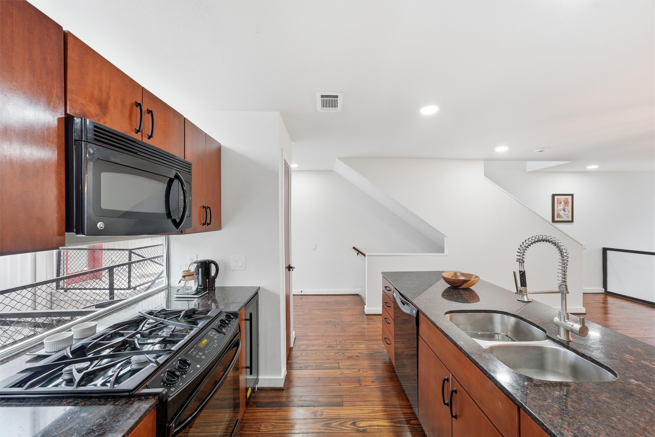 The kitchen has a window wall above and below the upper cabinets for even more light. Granite countertops. Gas range and built-in microwave. Wine fridge. Pantry.