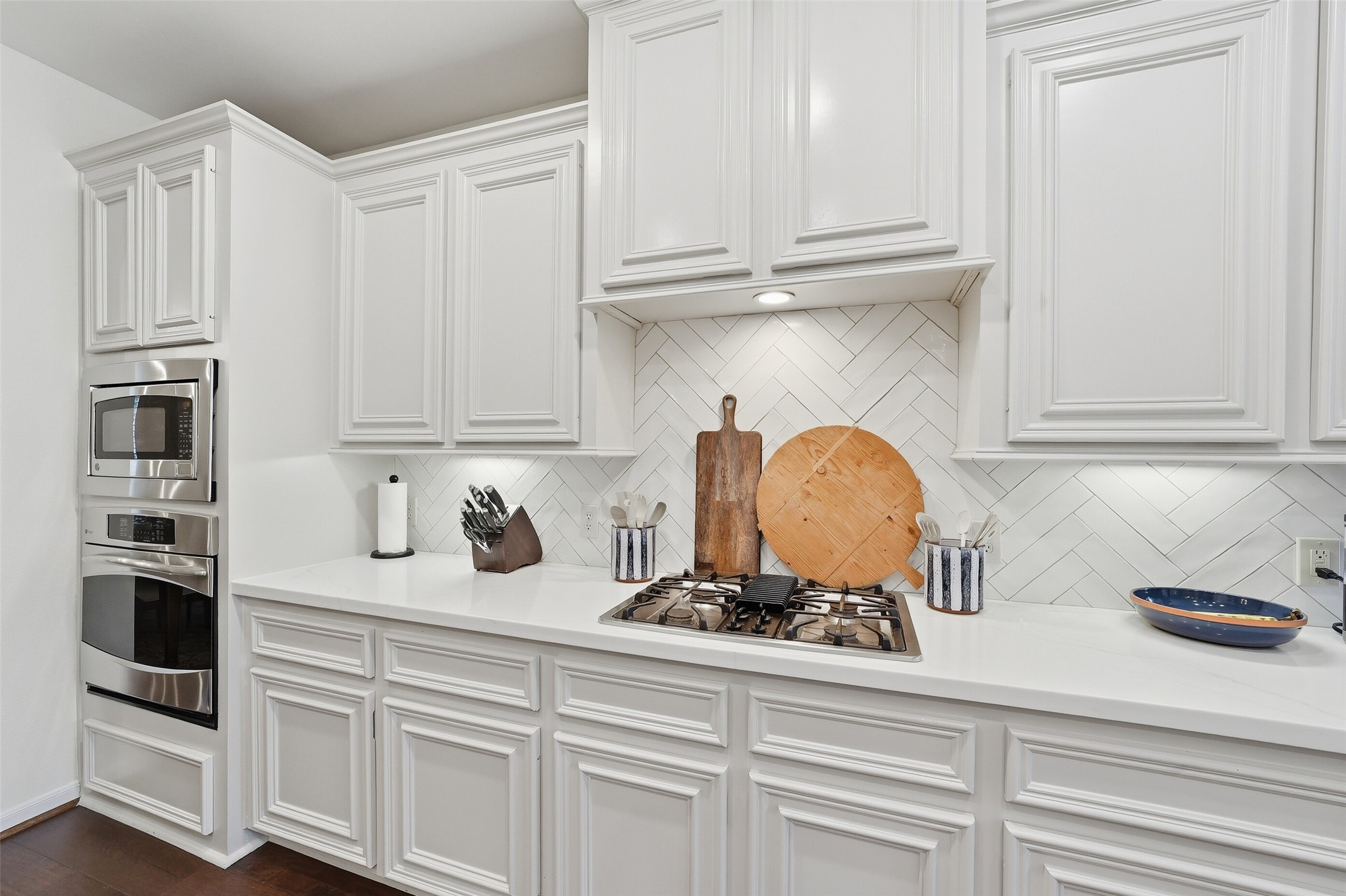 A custom herringbone backsplash and undercabinet lighting set off this space beautifully.