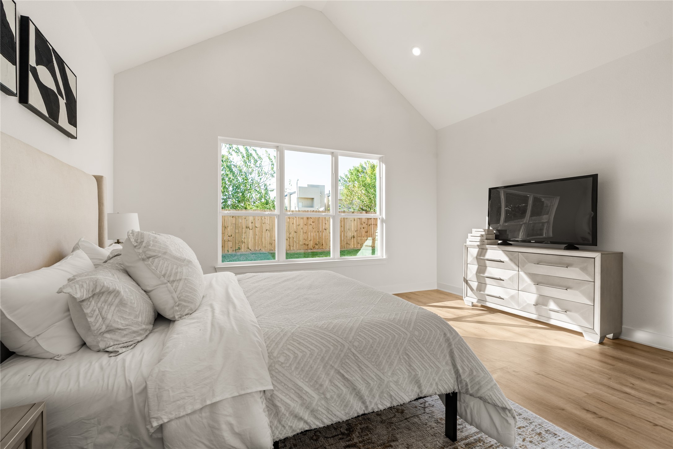 Morning sunlight filters through oversized windows overlooking the fenced backyard, creating a peaceful setting for the start of each day.
