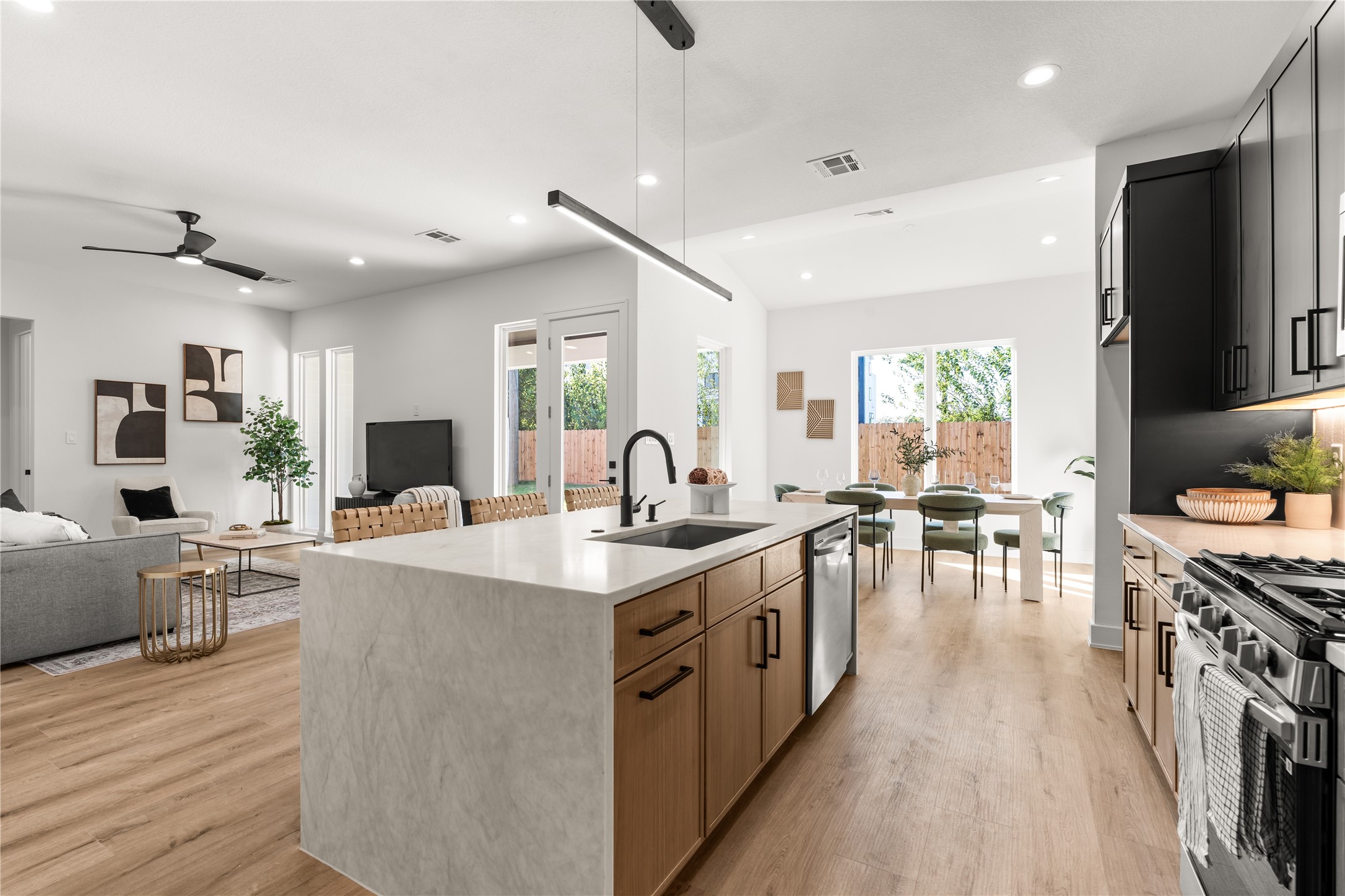 The kitchen's waterfall-edge Quartz Crystallo Lux island serves as a sculptural centerpiece, its softly veined surface cascading to the floor with a seamless, monolithic appearance.