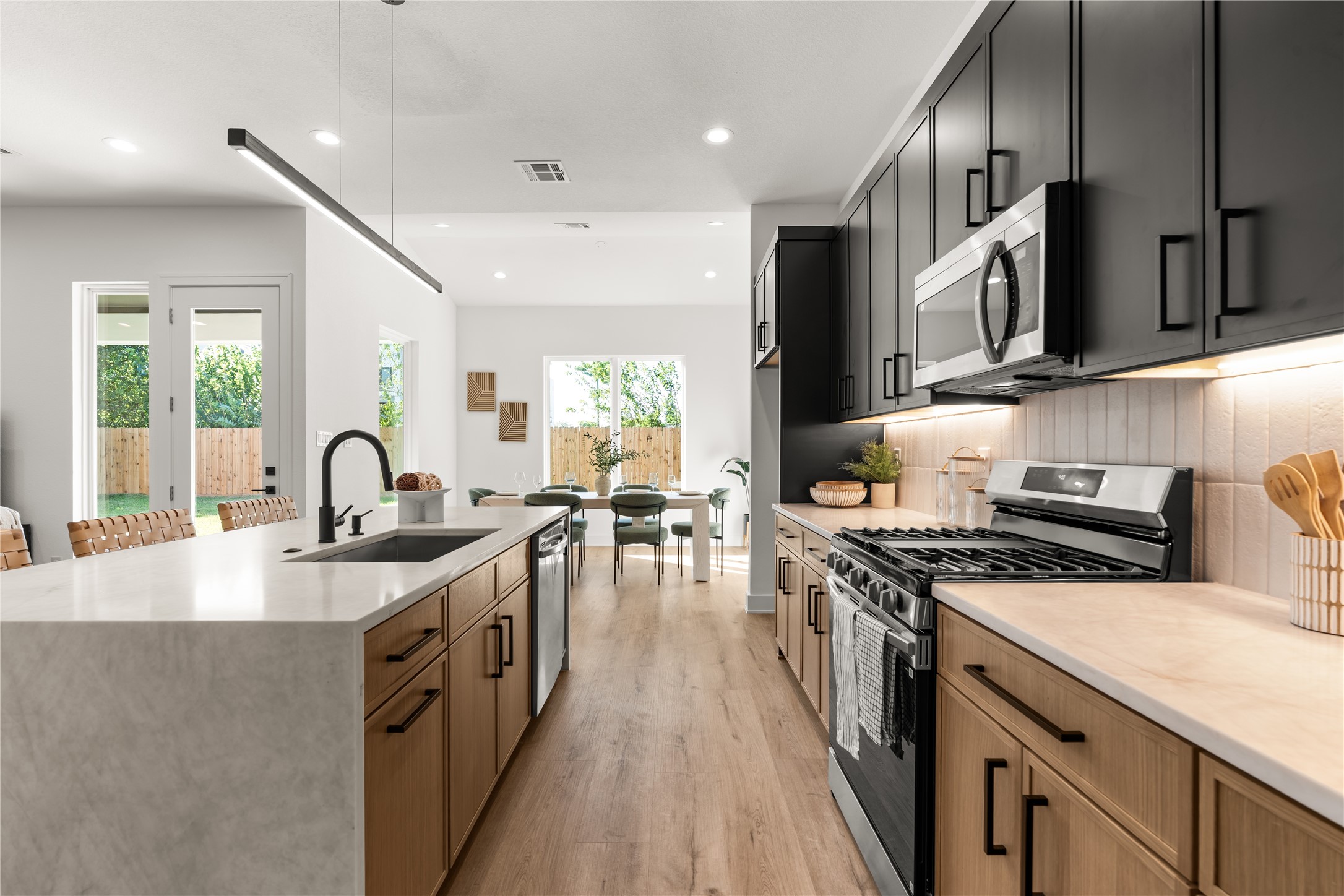 Natural light from the rear windows and patio entrance enhances the inviting atmosphere, making this a space designed as much for gathering as for cooking.