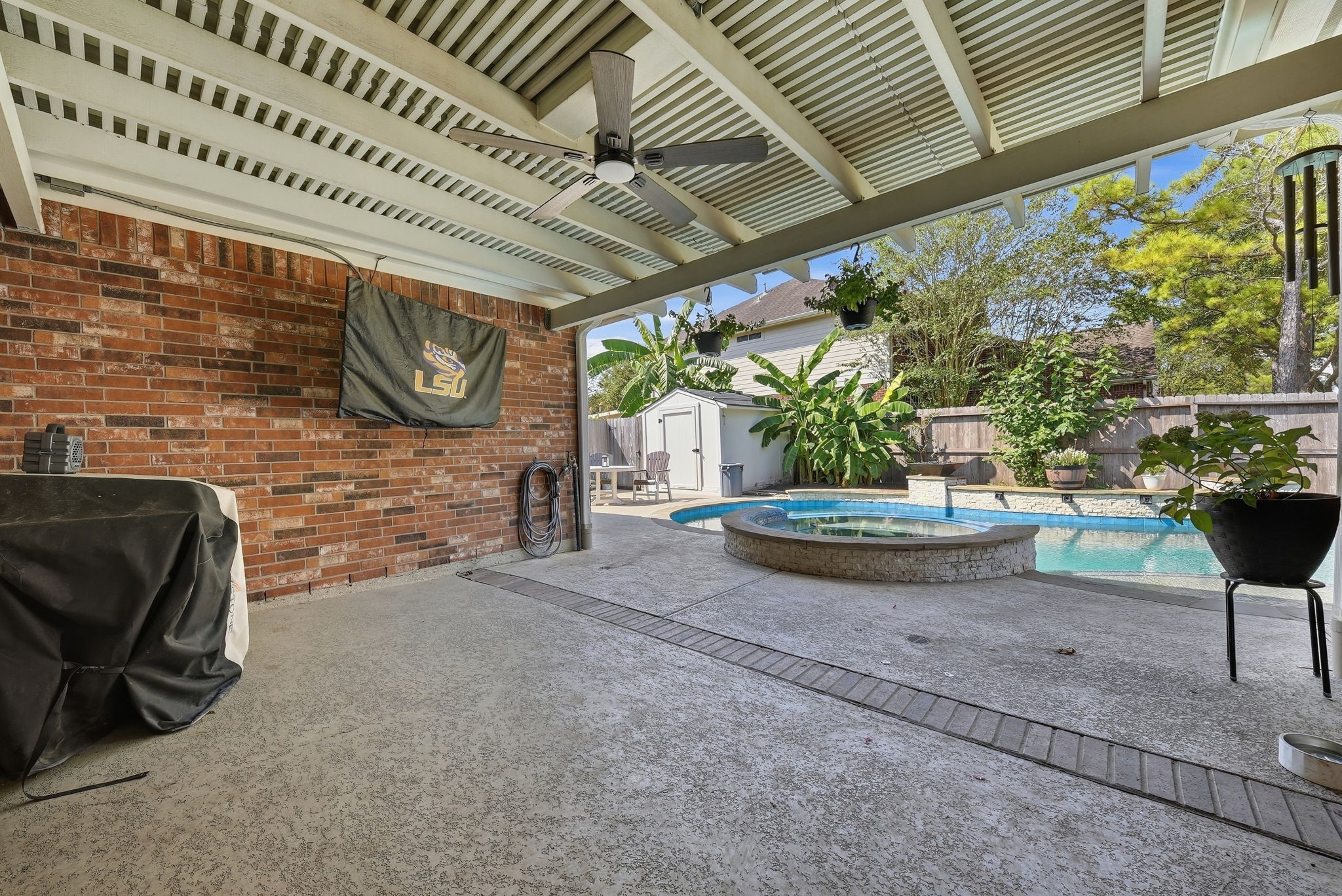 Covered patio with ceiling fan. Grill + TV not included.