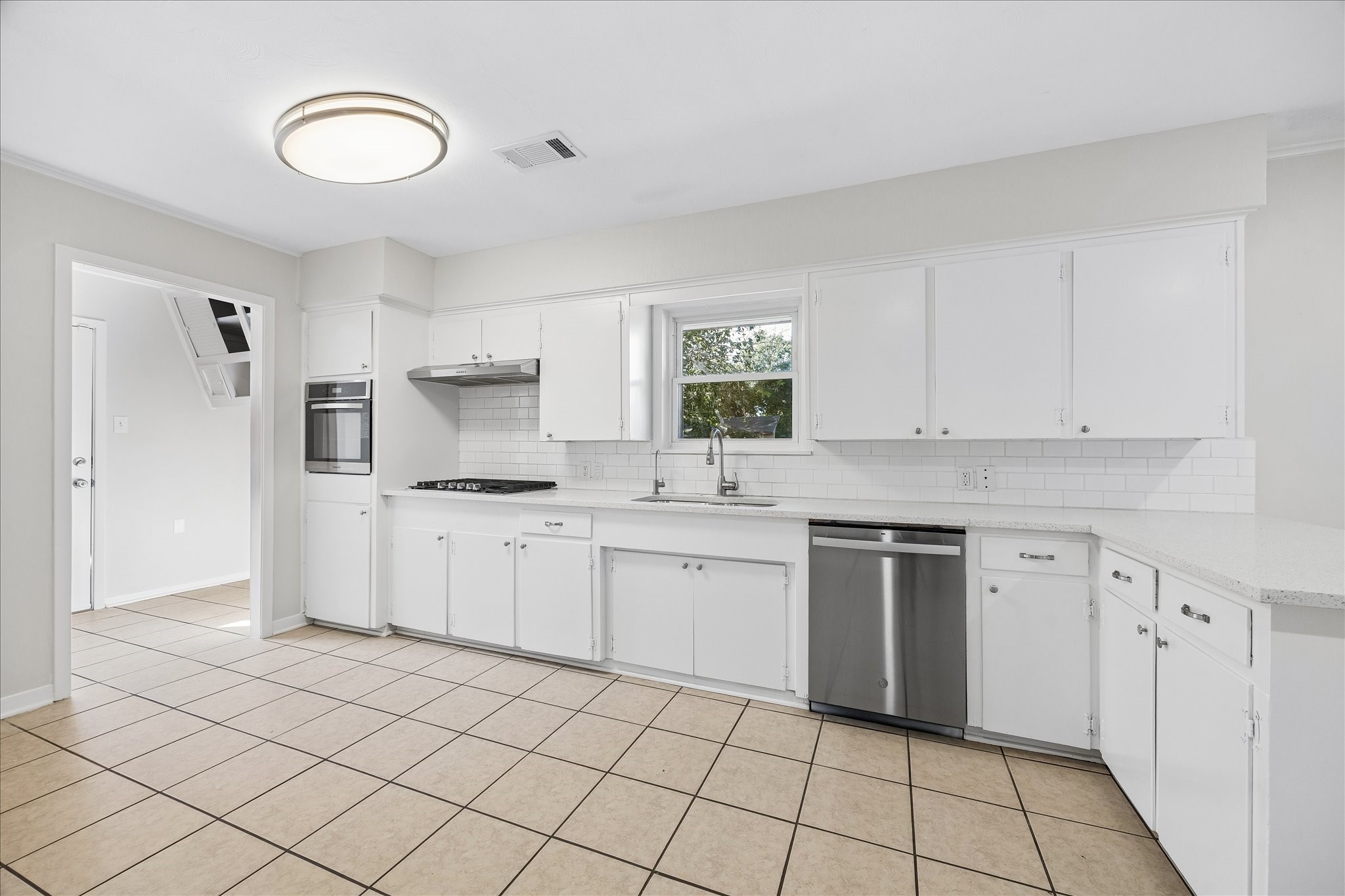 A view of the kitchen and the mudroom. Notice how light and bright this space is.