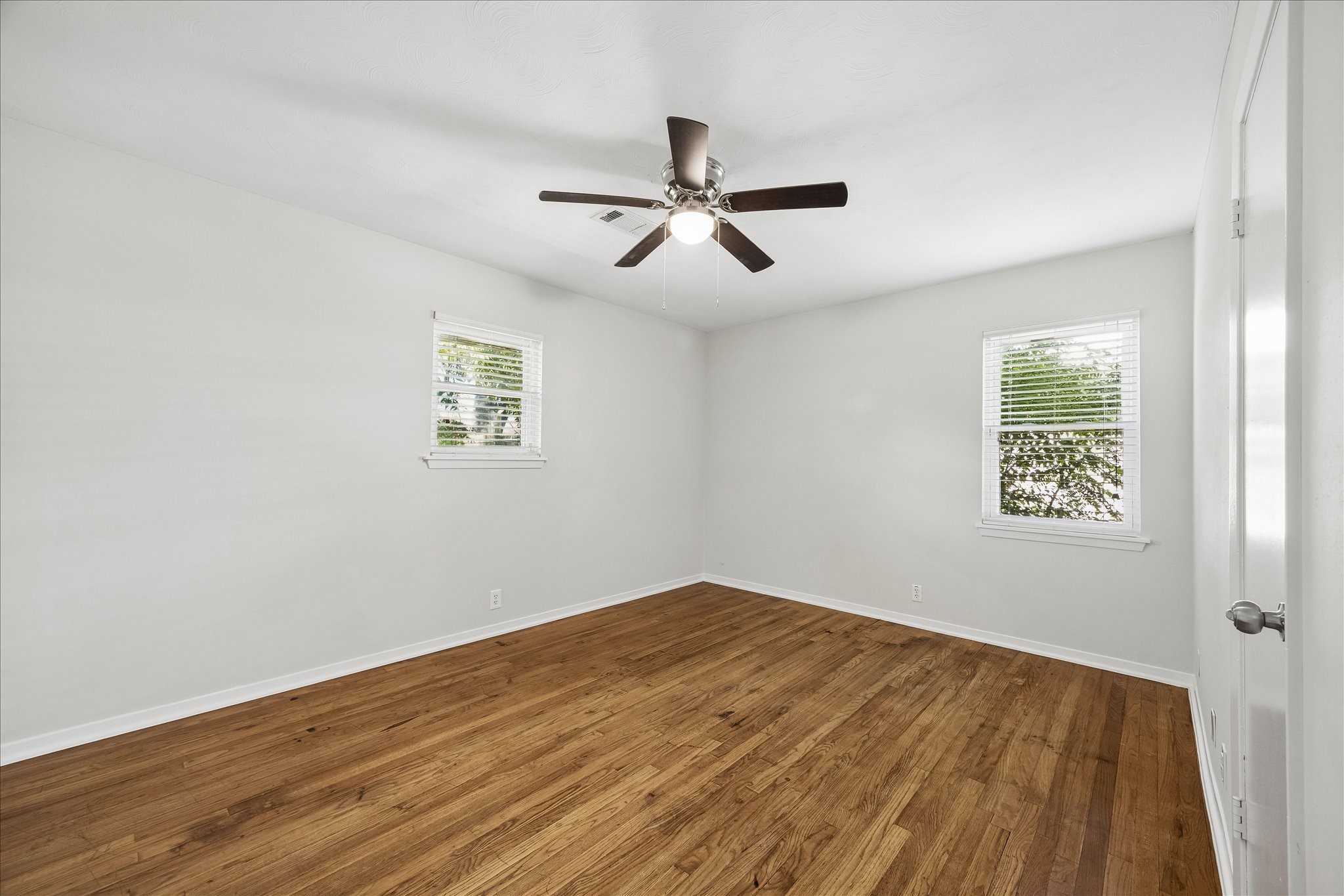 Bedroom 2 with neutral paint and wood floors.