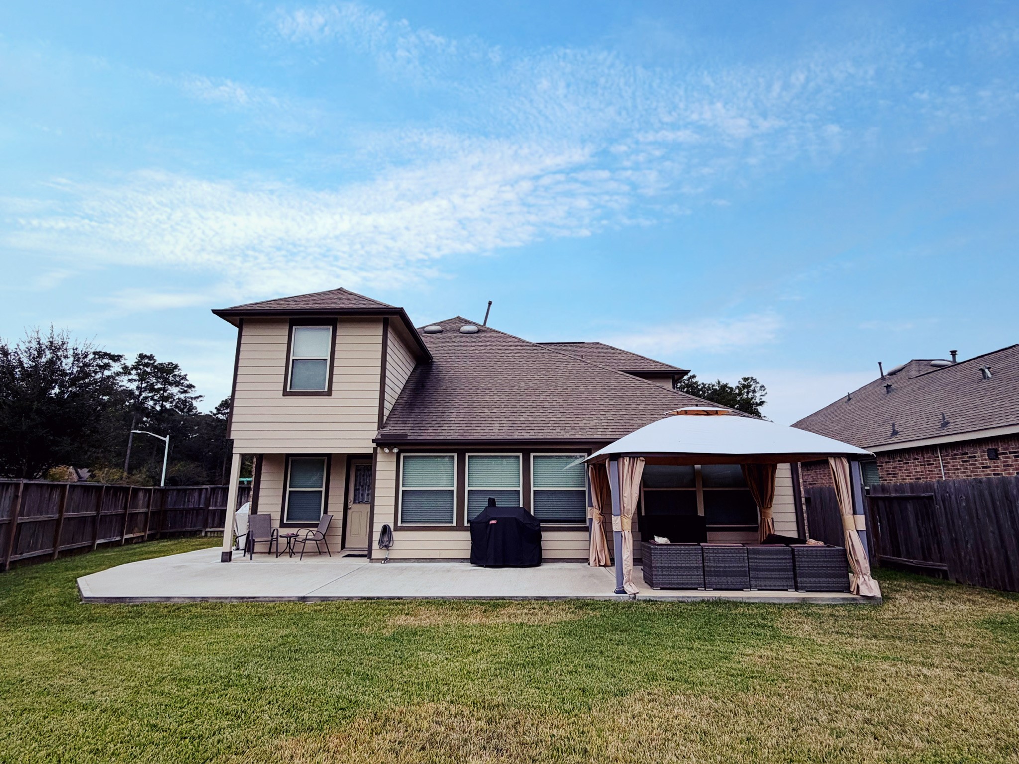 Charming two-story home with a spacious backyard, featuring a patio area and a covered gazebo. Perfect for outdoor entertaining and relaxation.