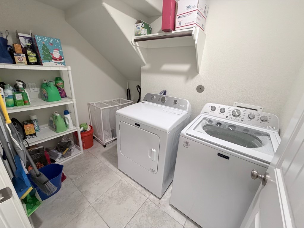 This perfect utility room:is spacious and organized, featuring modern laundry appliances and ample shelving for all your storage needs.