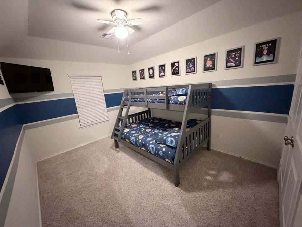 Discover the spacious 13x15 upstairs second bedroom, perfect for creativity and comfort, featuring playful decor and ample natural light.