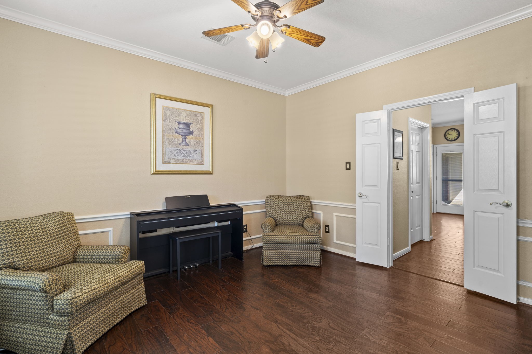 The formal dining room, currently utilized as a music room, is conveniently located adjacent to the kitchen, offering a versatile space ideal for entertaining or creative use.