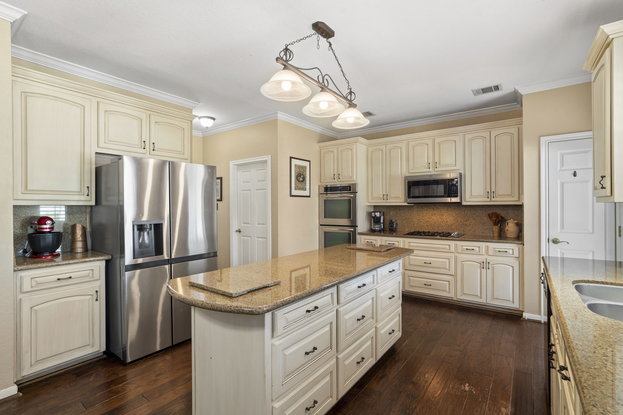 Updated appliances include double convection ovens, a microwave, a gas cooktop, and a built-in dishwasher.