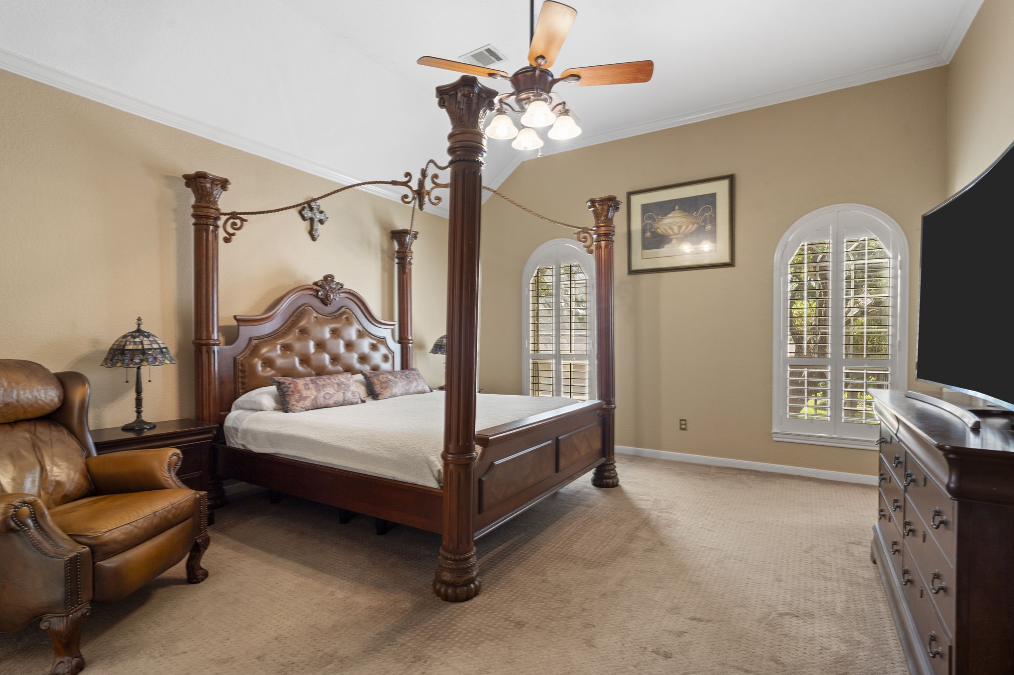 The spacious primary suite features a high ceiling, elegant arched windows, a huge walk-in closet, and a luxurious spa-inspired en suite bathroom.