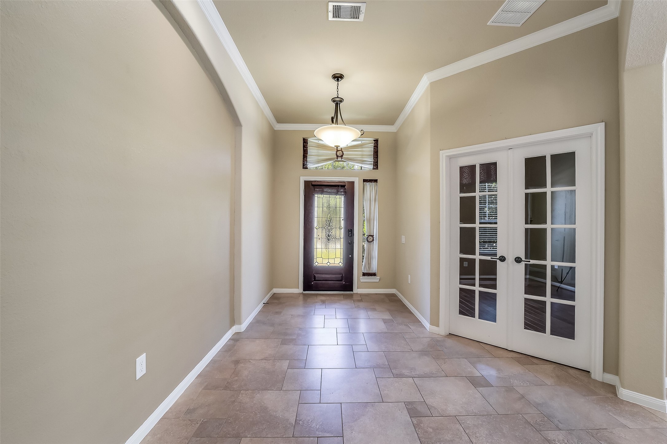 Double French doors at entry hall lead to a private study/library.
