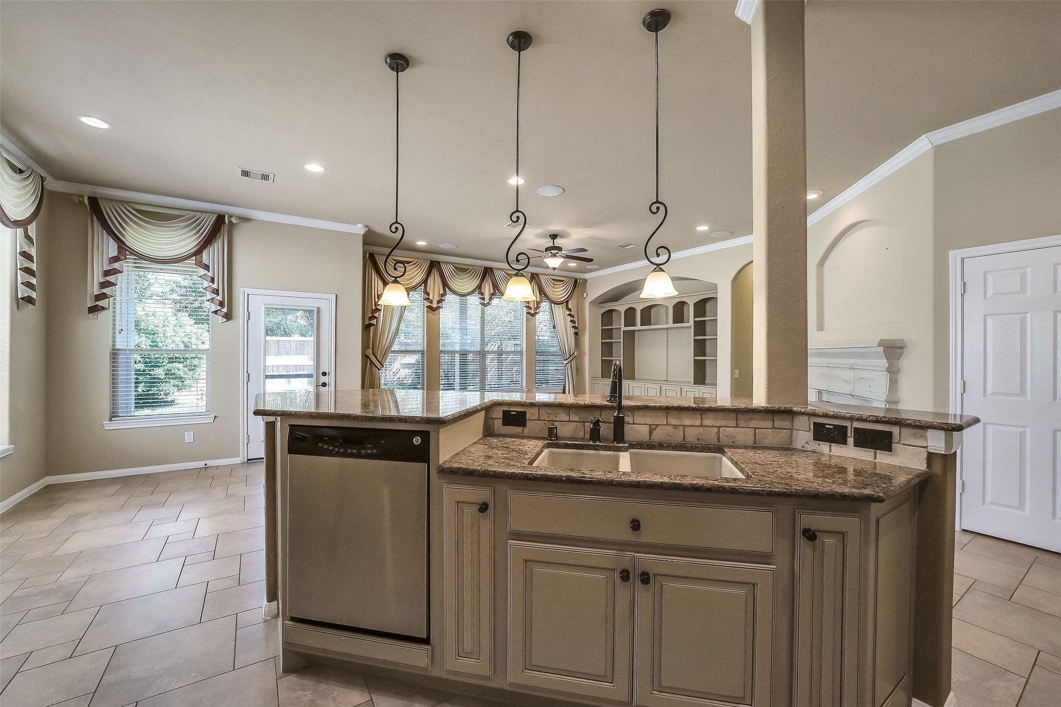 Raised dishwasher is easier to load and unload. Undermount cream colored porcelain sink and bronze toned fixtures and cabinet hardware.