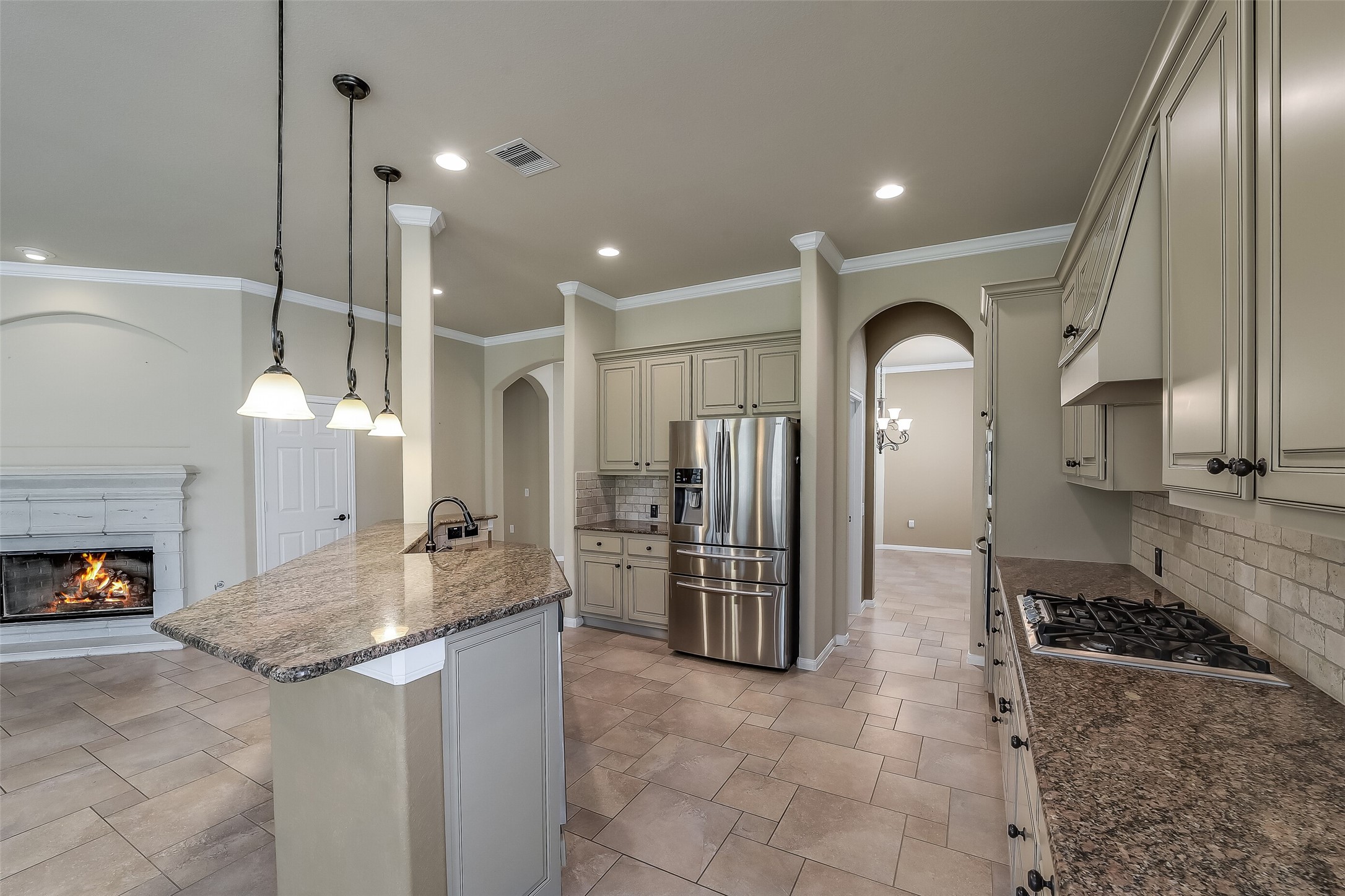 Lots of sleek granite counters, stone back splash and tall cabinets.