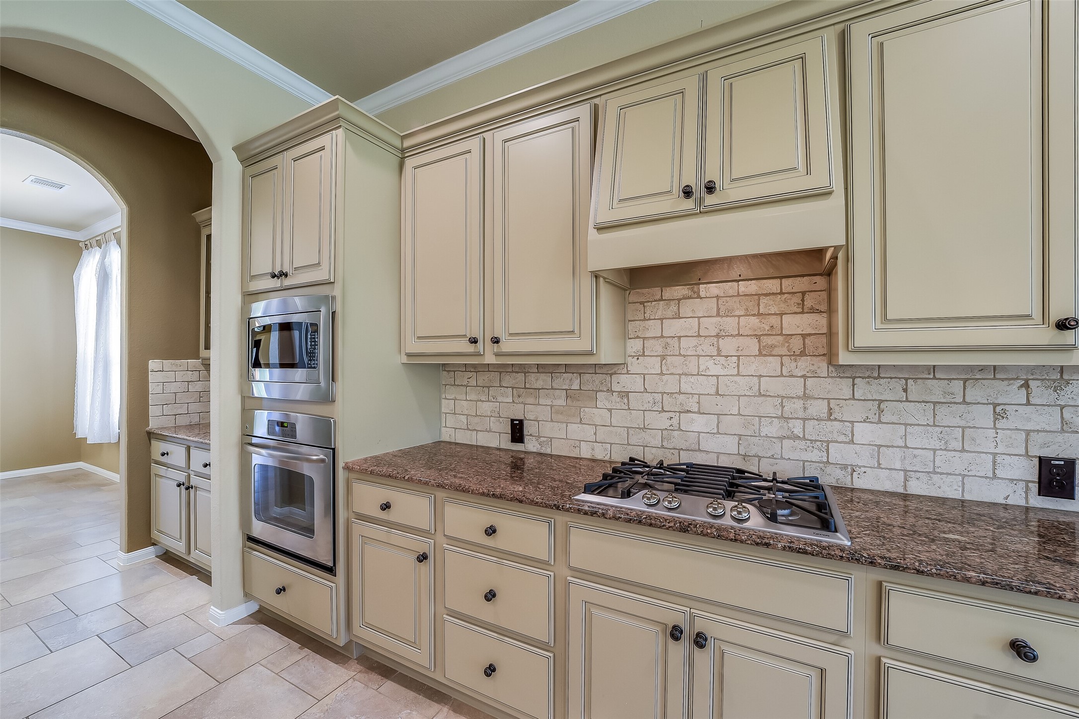 Gas vooktop with vent hood above. Wall mount oven and microwave.