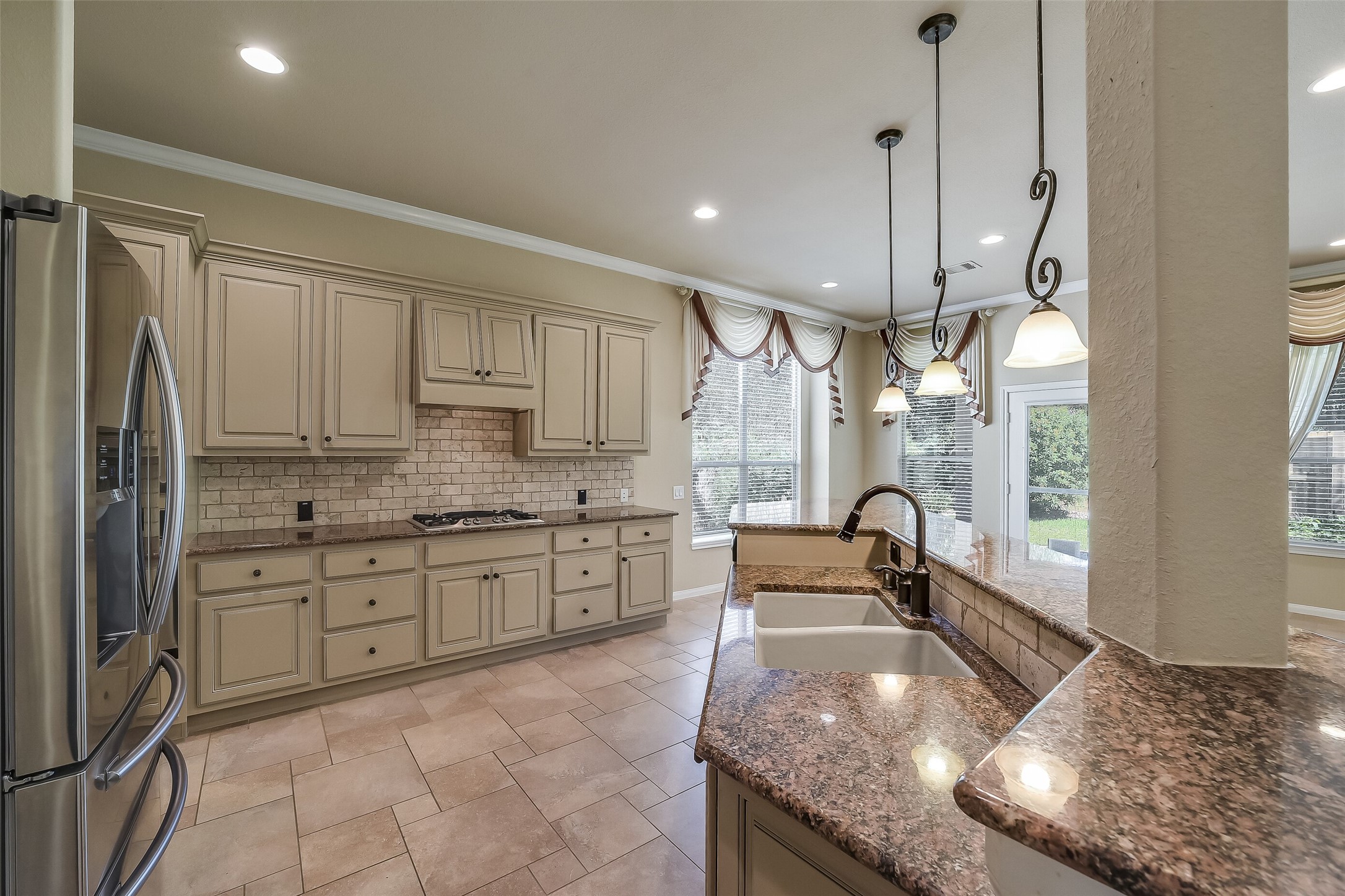 Upgraded cabinetry, stainless appliances include a gas cook top and a refrigerator with water/ice dispenser.