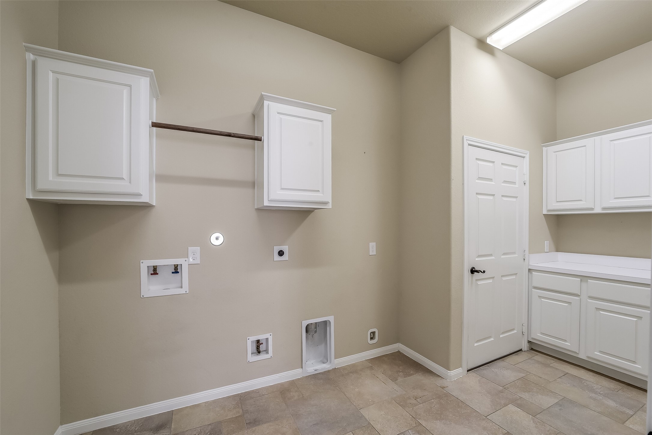 Nice size utility room with gas dryer connection, storage cabinets, counter space and room for an extra refridgerator.