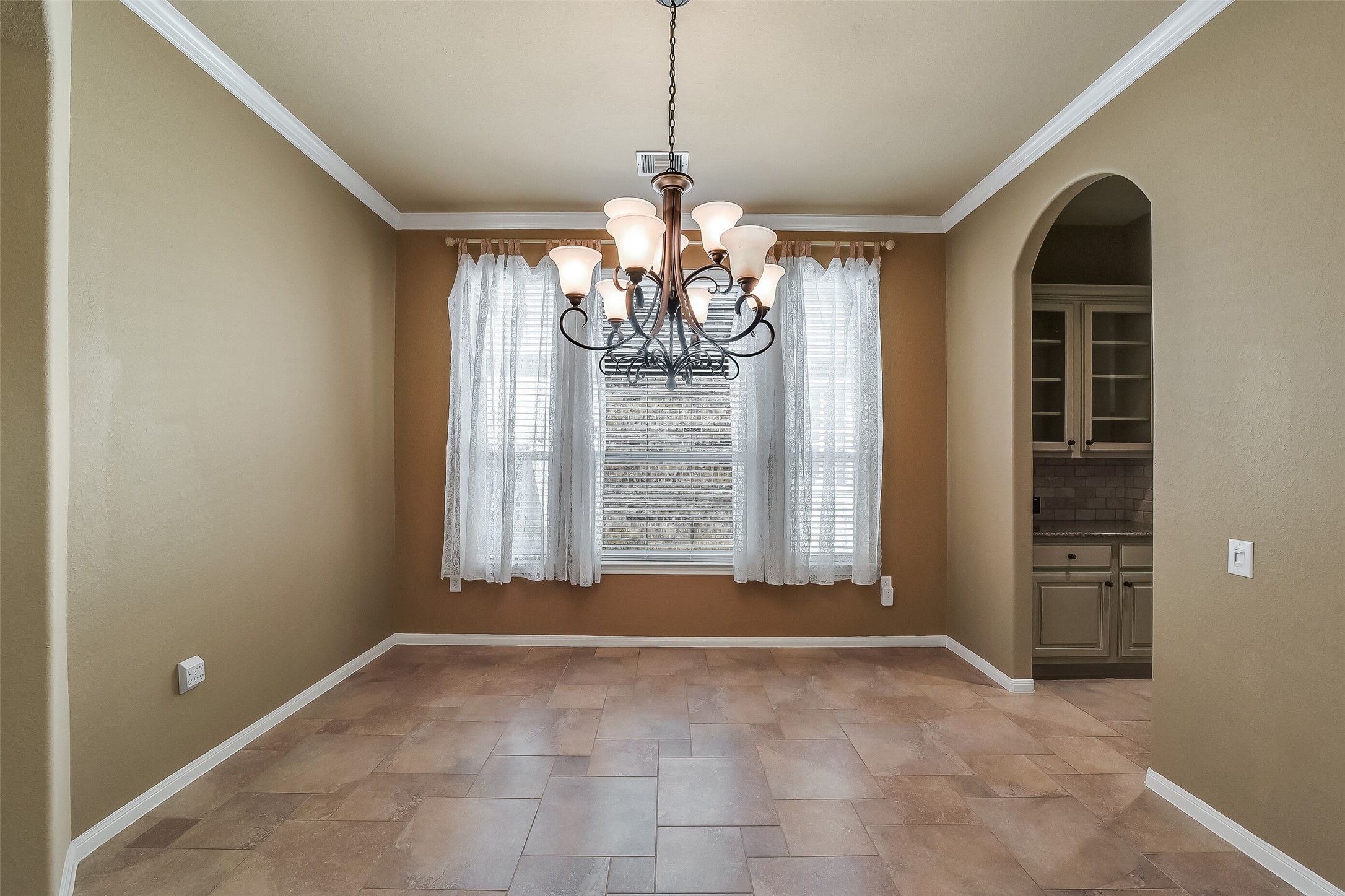 The dining room has a grand chandelier and a convenient entry to the kitchen via the butler's pantry.