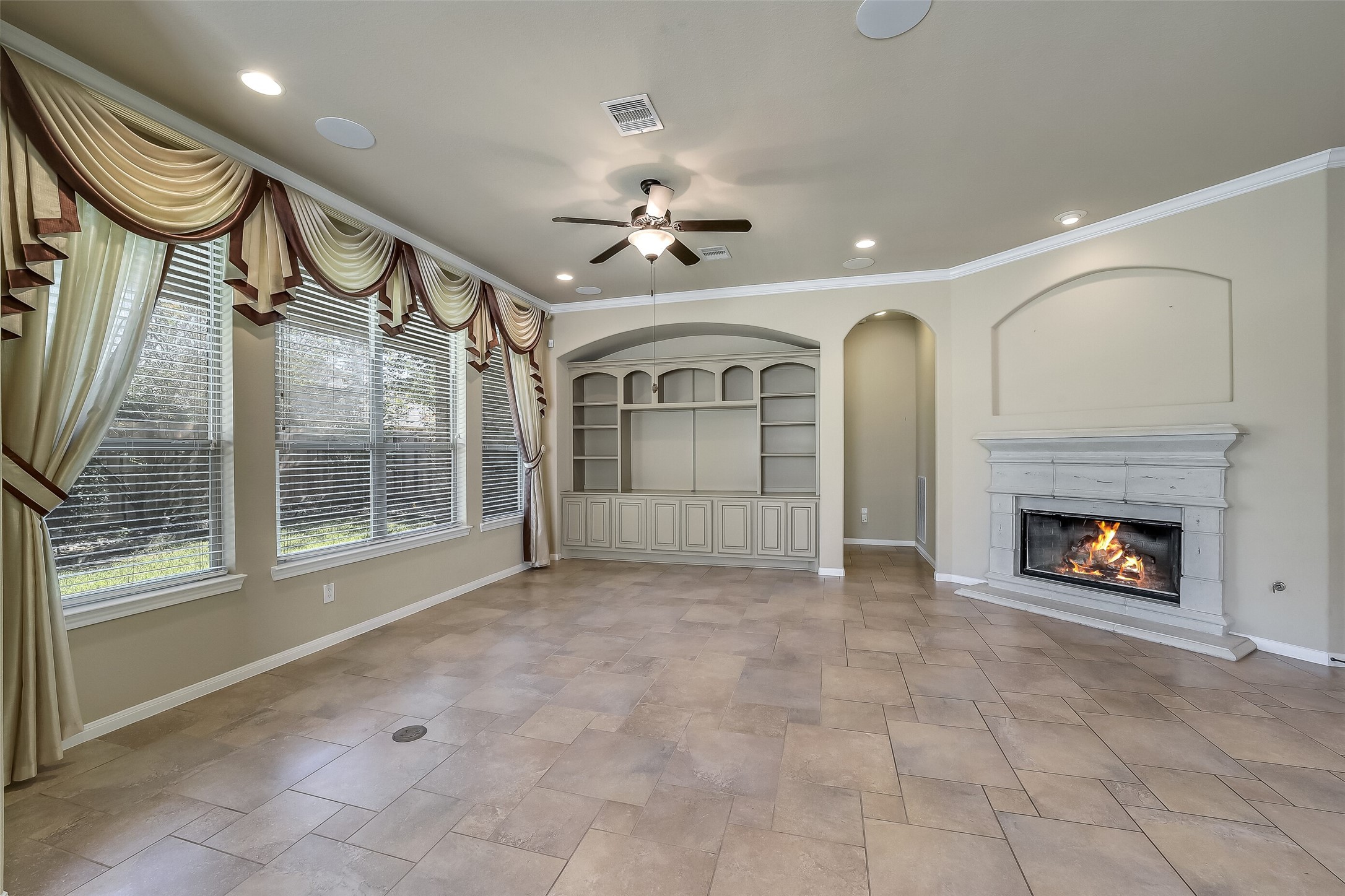 Custom built-in book shelves and cabinets and a nice sized space for TV niche. The family room offers a corner gas log fireplace and great big windows overlooking the landscaped back yard.