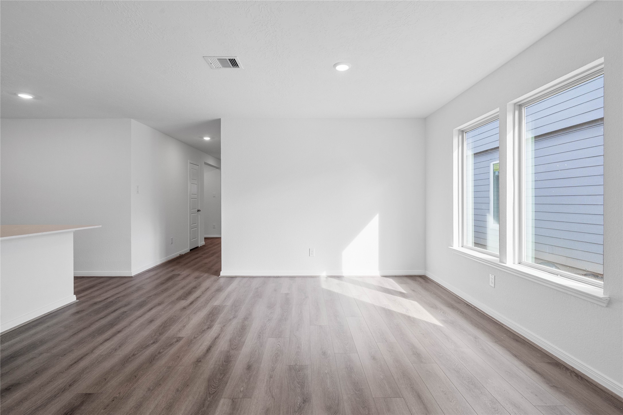 Start your day with a warm cup of coffee and quality time in this charming dining area! Highlights include large windows, custom neutral paint, vinyl plank flooring, and high ceilings with recessed lighting.