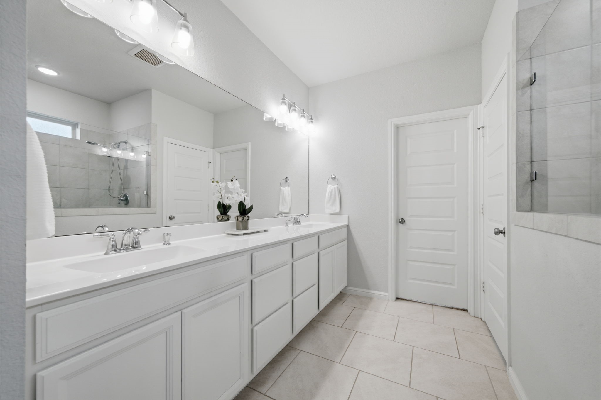 Primary bathroom features double sinks, cabinets, and drawers for storage.