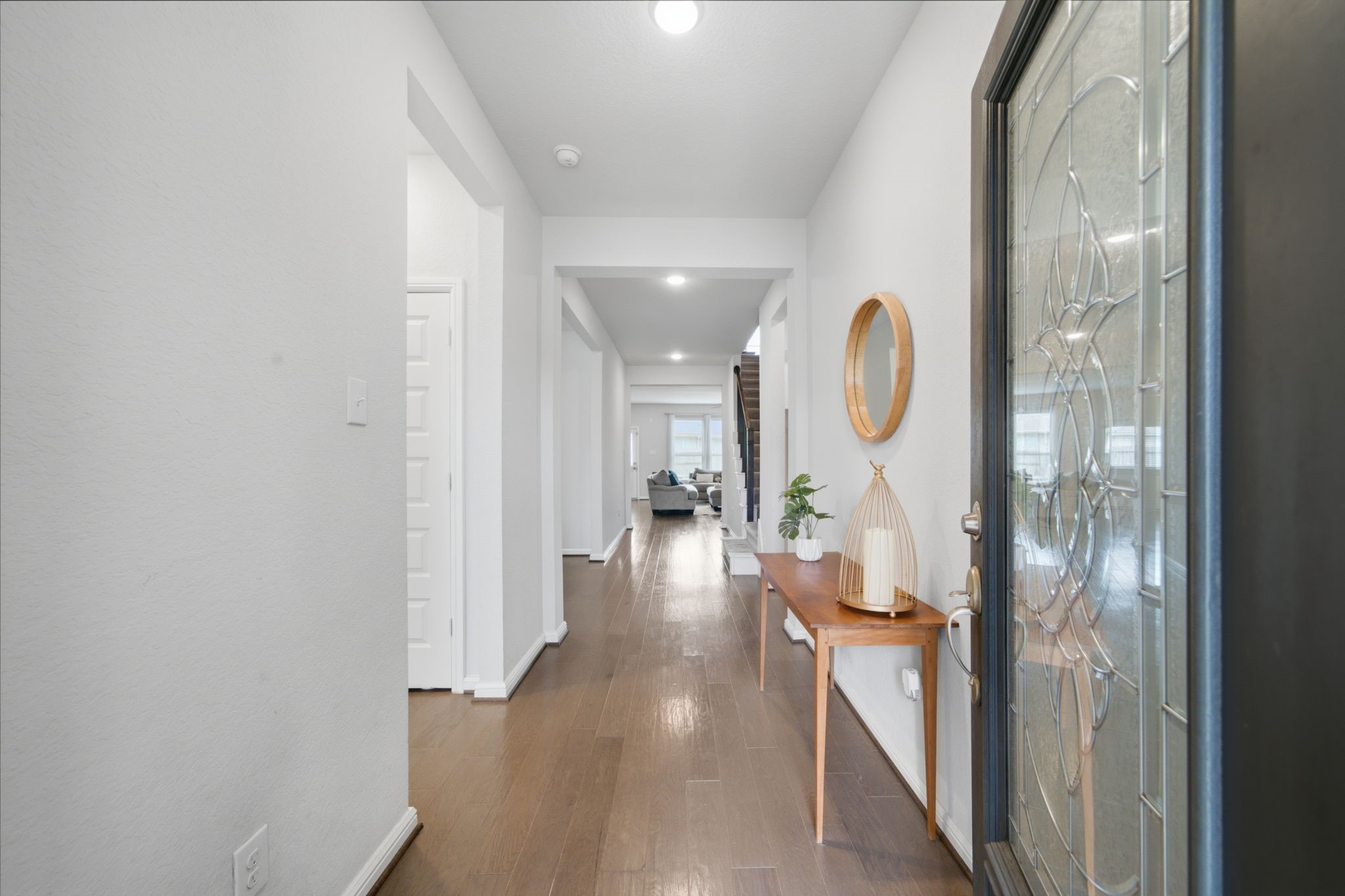 Elegant entryway with sleek wood-look tile, leading to a bright and inviting foyer. Elegant entryway with sleek wood-look tile, leading to a bright and inviting foyer.
