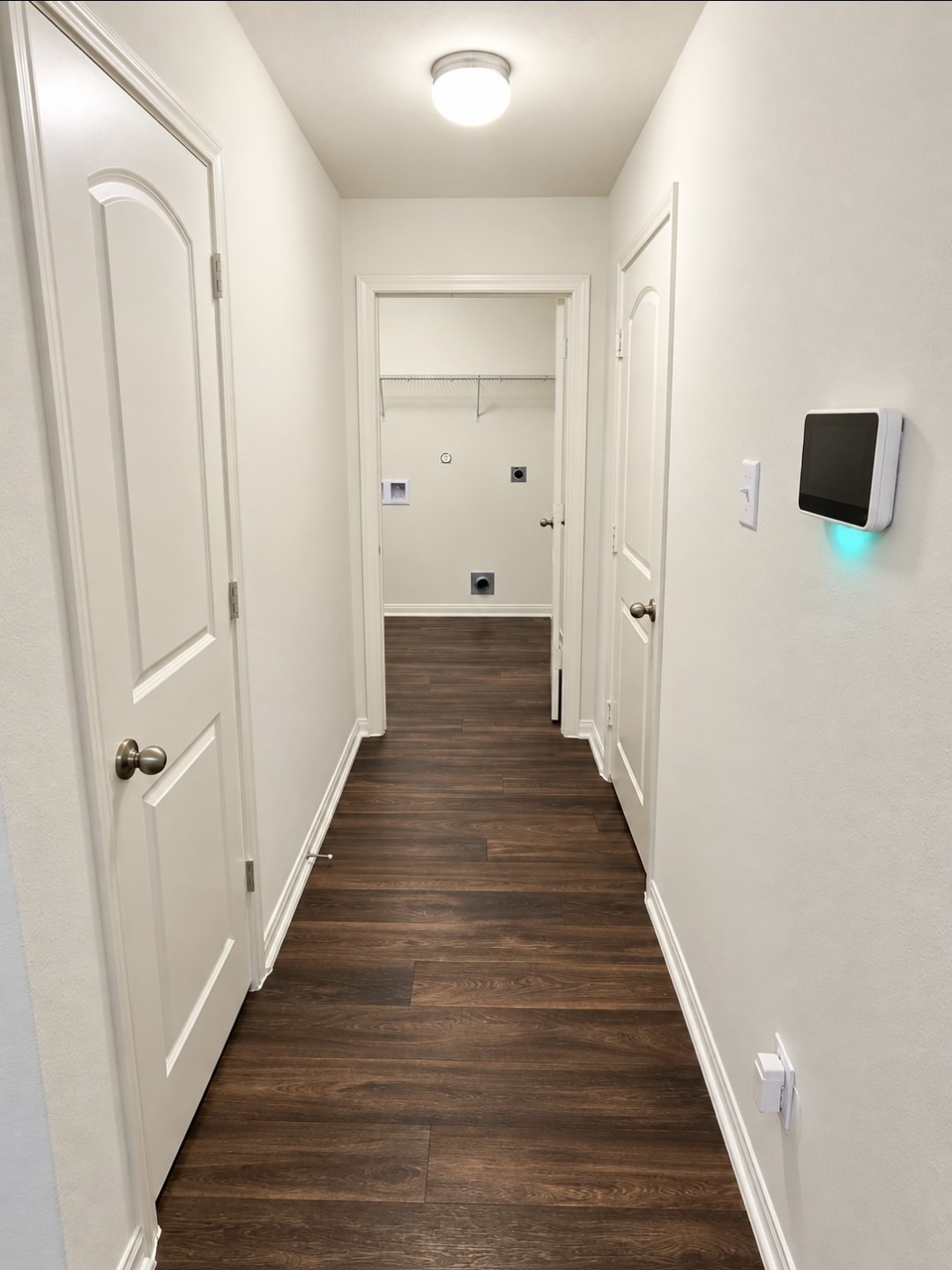 Hallway leading to the utility room with pantry on the left and garage door to your right.
