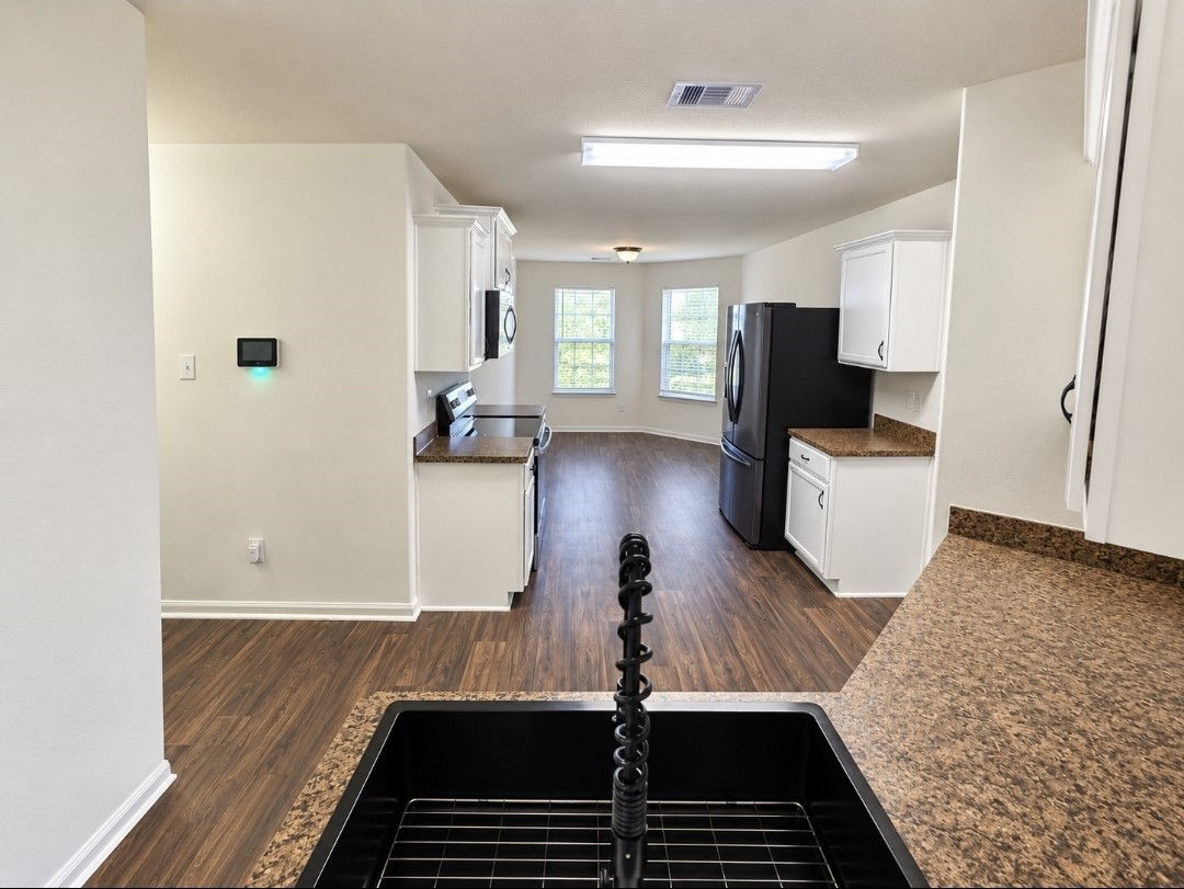 Kitchen with a brand-new oven and oversized size. Black stainless steel fridge to convey.