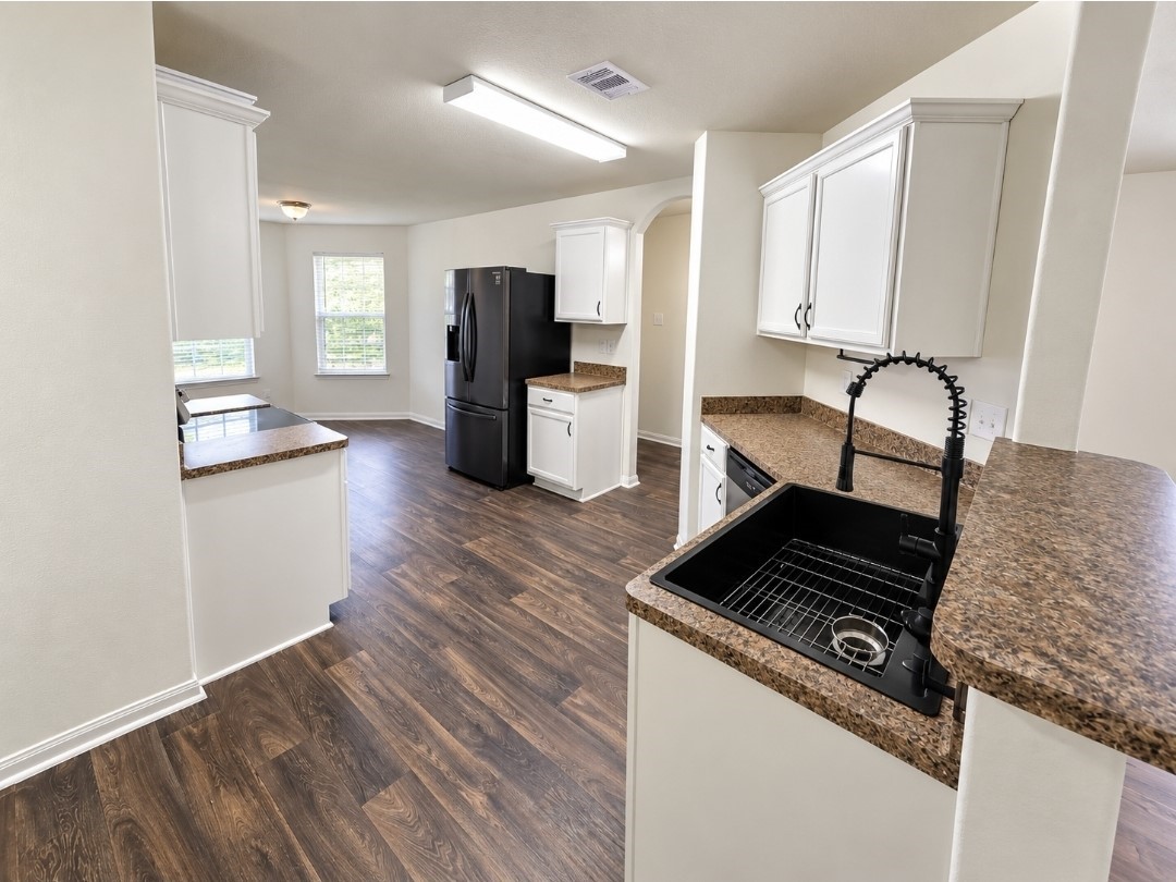 Kitchen with a brand-new oven and oversized size. Black stainless steel fridge to convey.