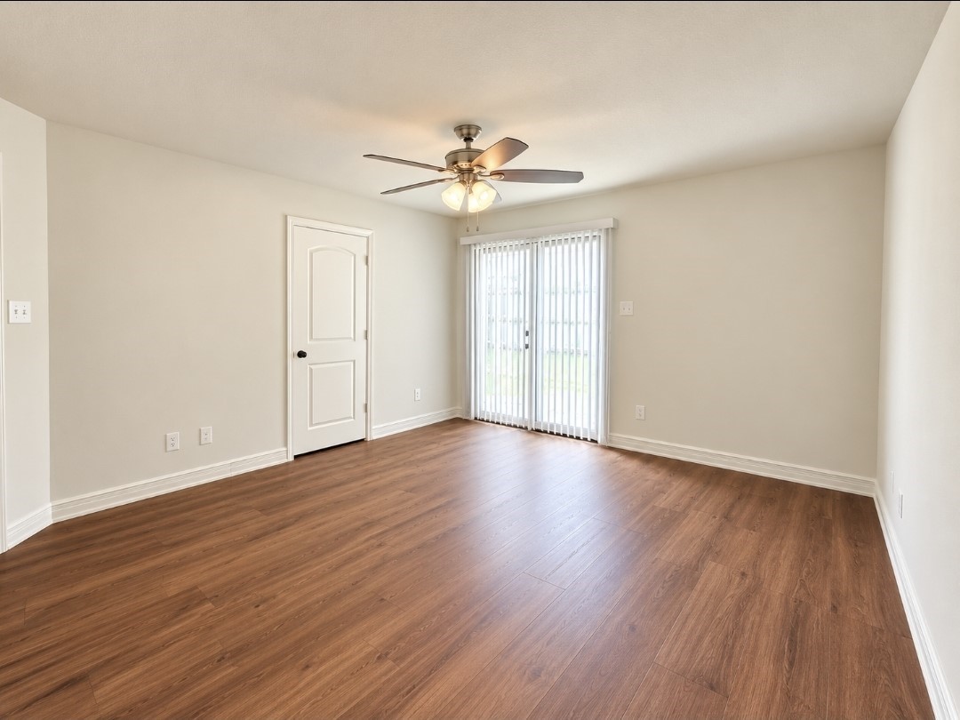 Primary bedroom with brand-new luxury vinyl plank flooring with private sliding glass door into the backyard.
