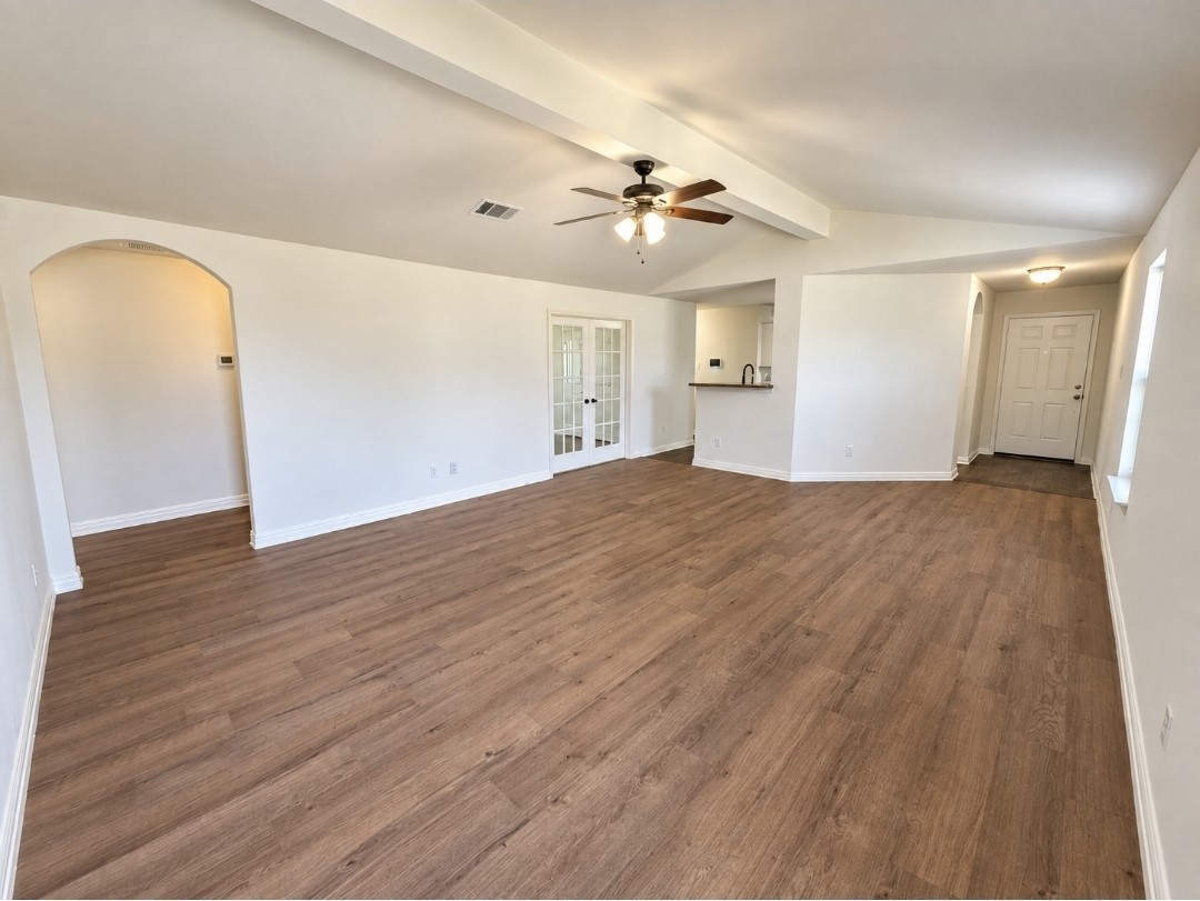 The spacious living room has brand-new luxury vinyl flooring and high ceilings.