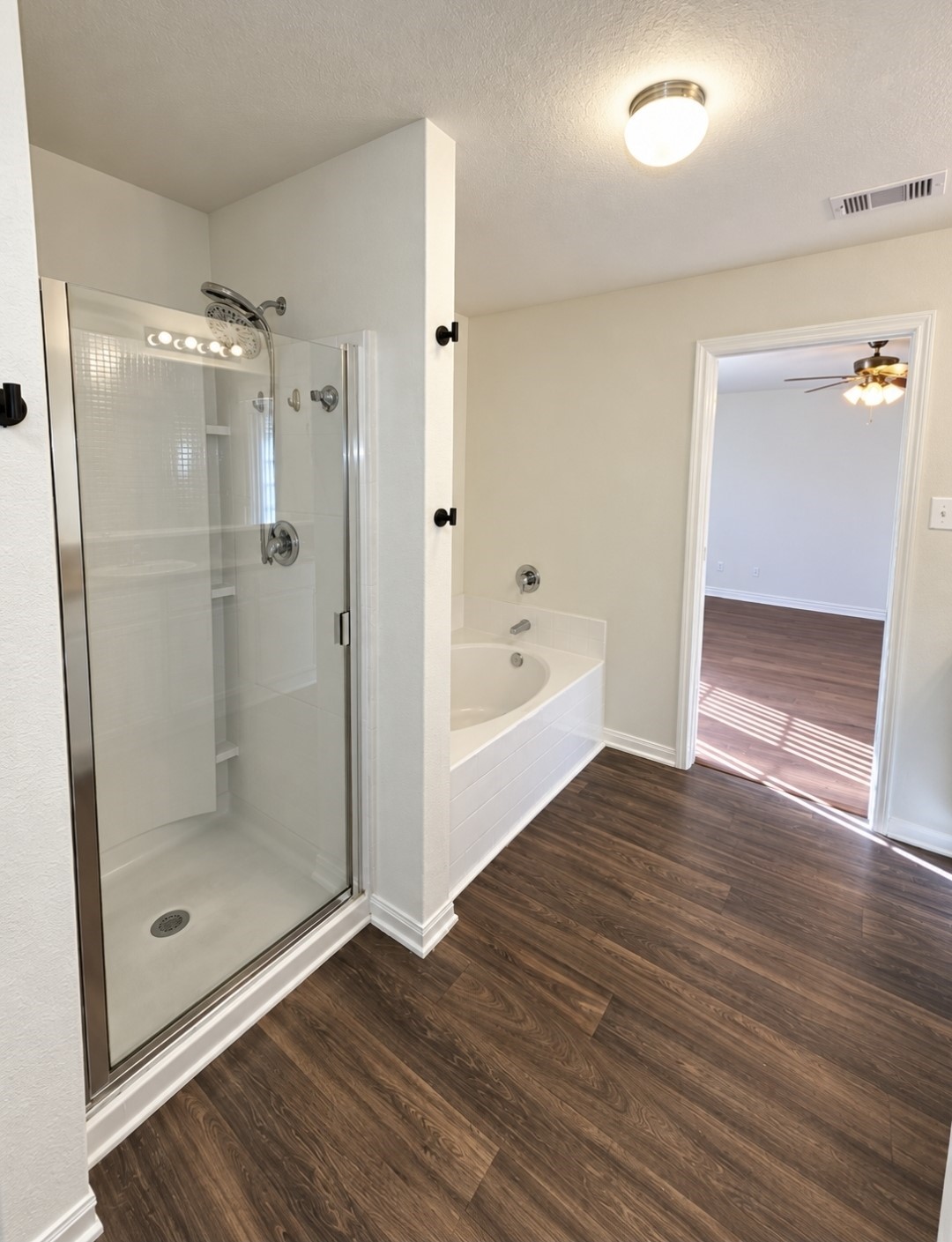 An oversized soaking tub and seperate walk-in shower with half wall toilet area.