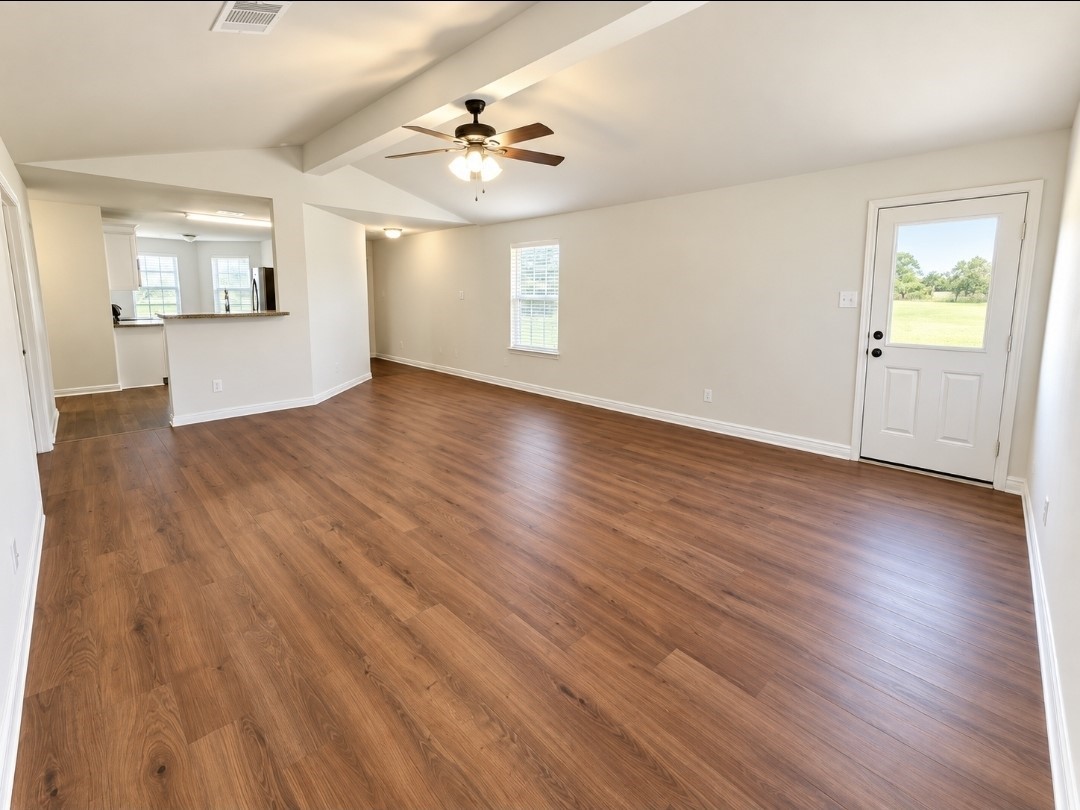 The spacious living room has brand-new luxury vinyl flooring and high ceilings.