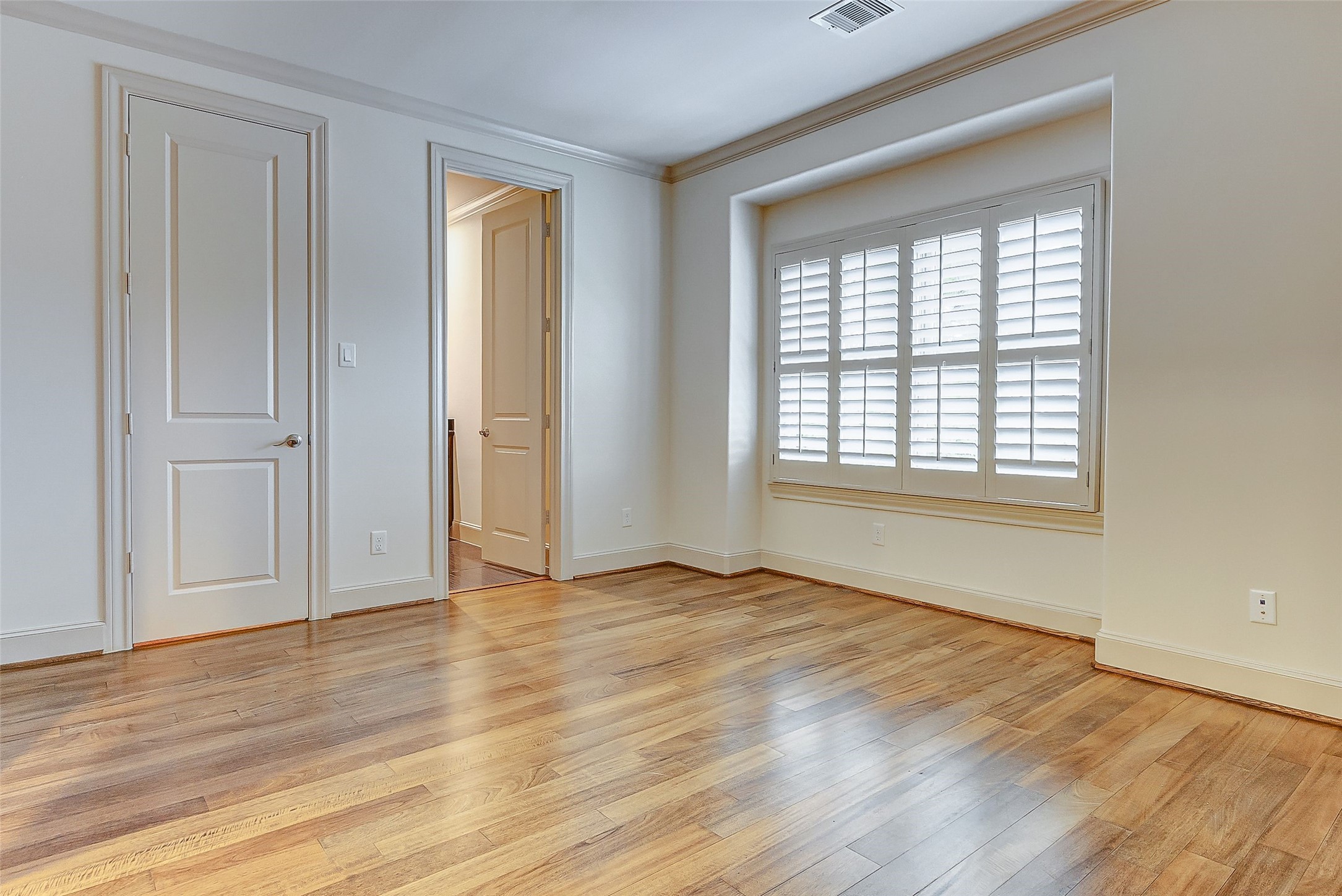 Upstairs, the secondary bedroom offers a bright and airy atmosphere, easily accommodating a queen-size bed and nightstands.