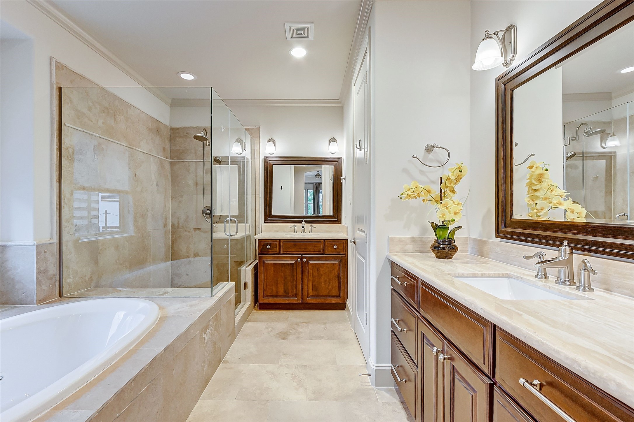 Indulge in luxury with a primary bath featuring a jetted spa bathtub, spacious walk-in shower with a bench, dual sinks, a private toilet room, and ample closet space.