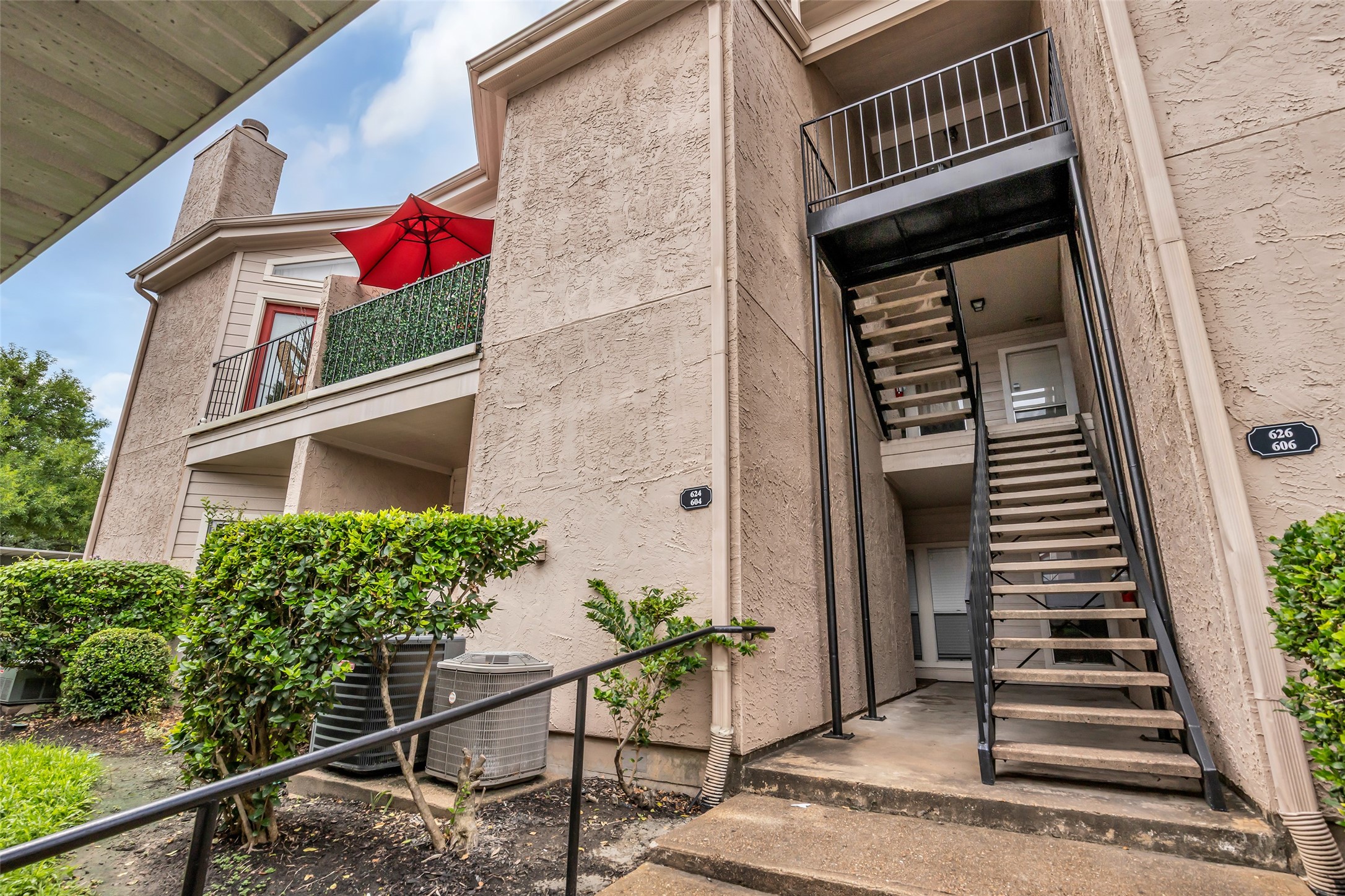 The condo entrance features an inviting exterior with a combination of wood and brick, creating a warm and classic look.