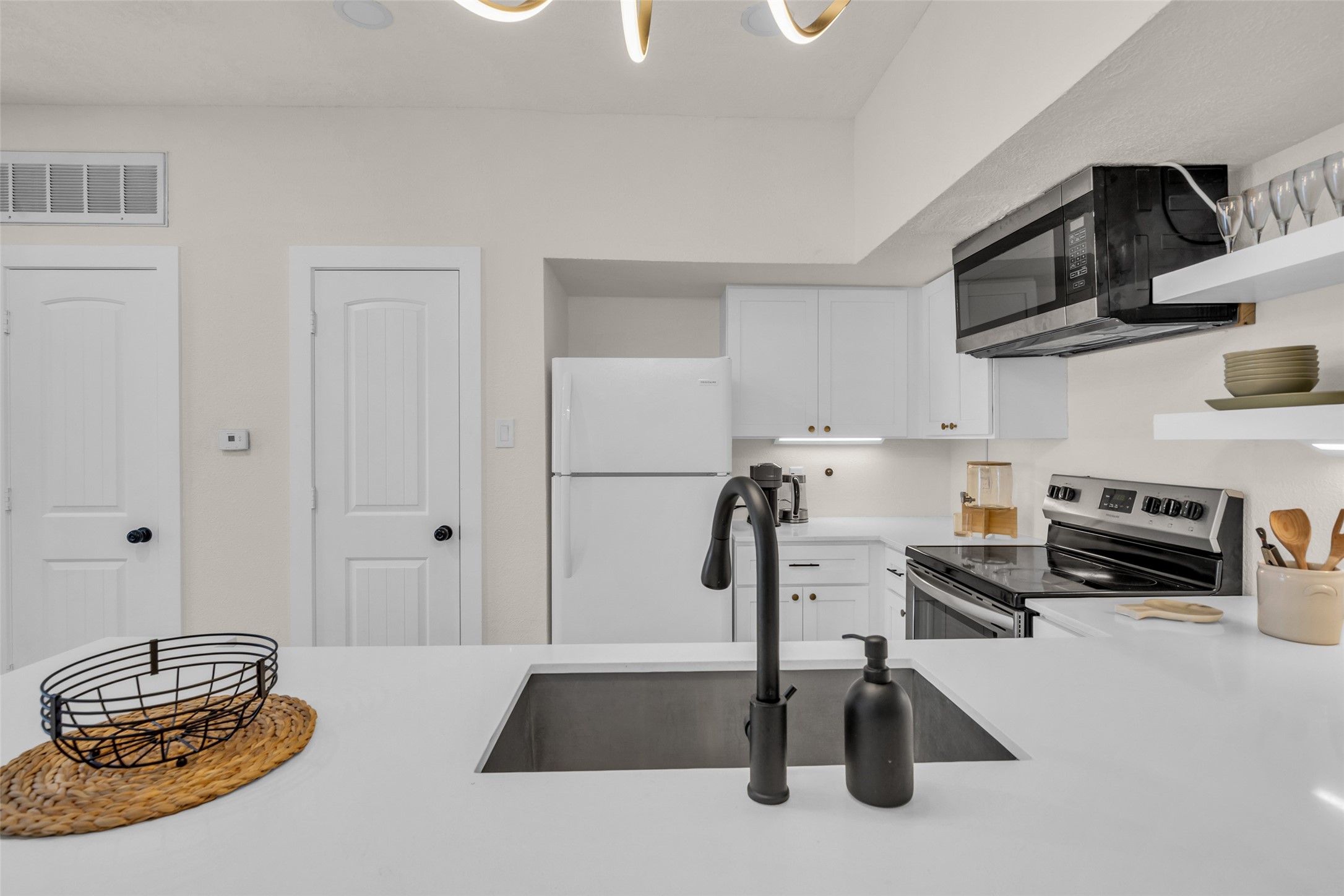 The space includes a small pantry for added storage, while the island provides extra counter space and a convenient spot for casual dining.