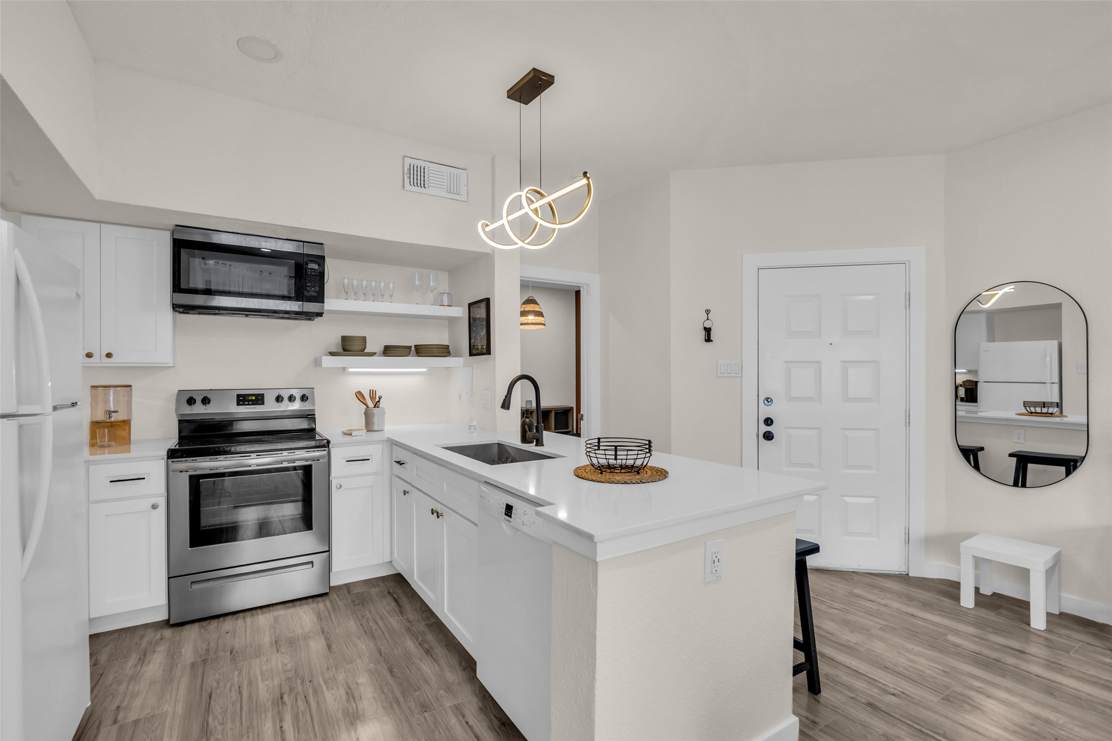 A central kitchen island provides additional prep area while doubling as a convenient breakfast bar for casual meals.