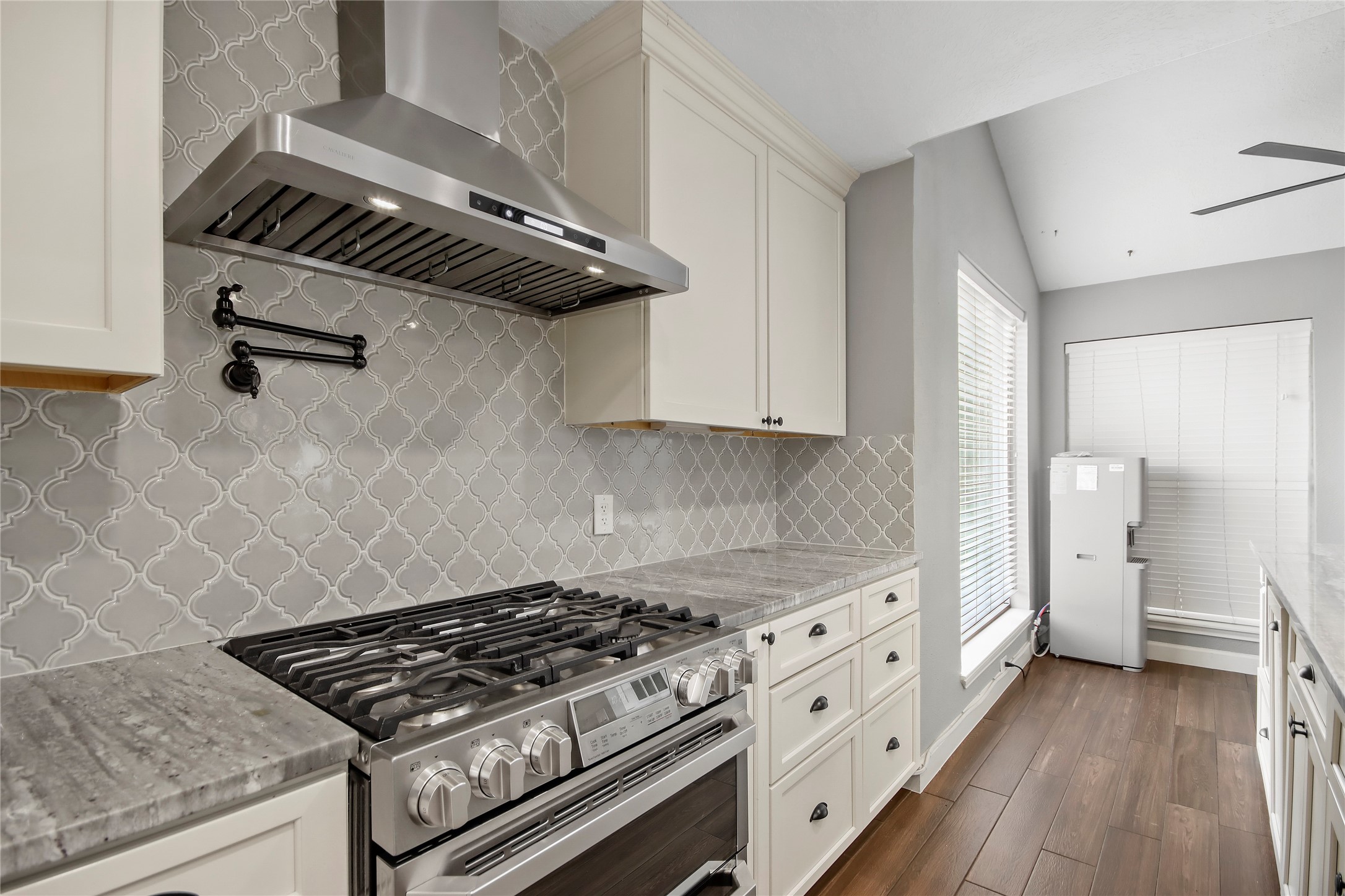 A gas range with pot filler and sleek vent hood make this kitchen as functional as it is beautiful. A gas range with pot filler and sleek vent hood make this kitchen as functional as it is beautiful.